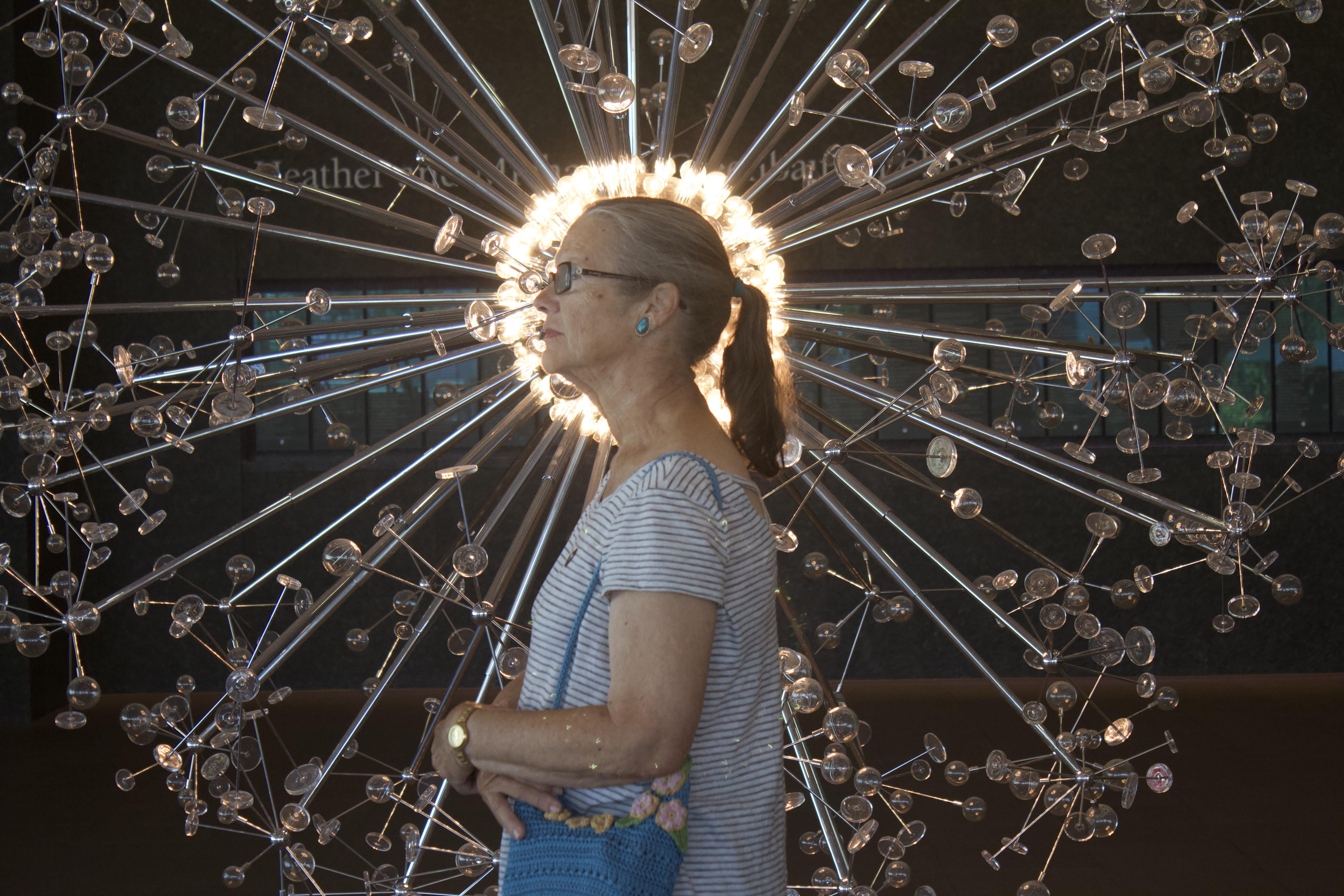 A woman standing in front of a sculpture