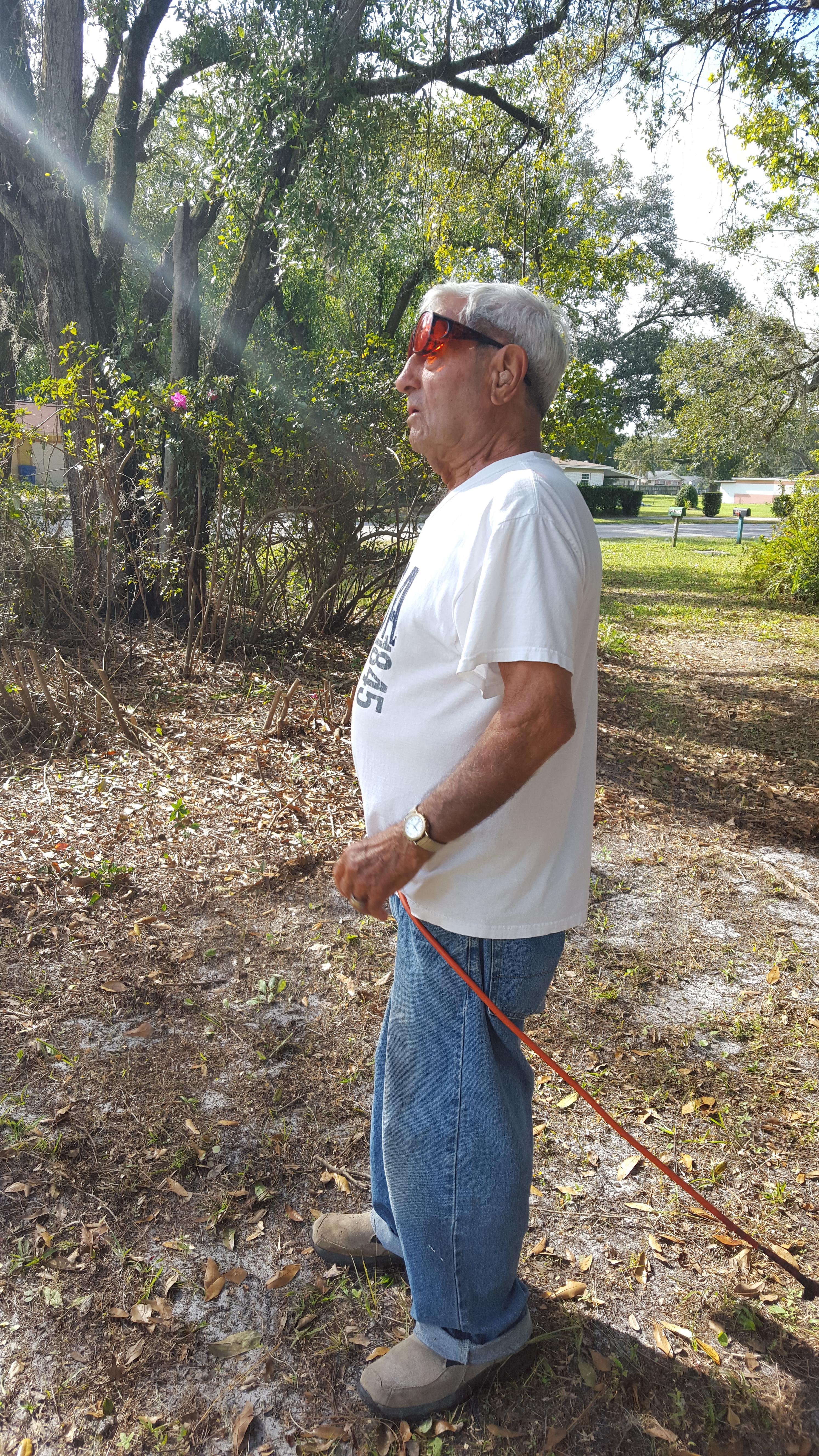 A man standing outside with a red rope