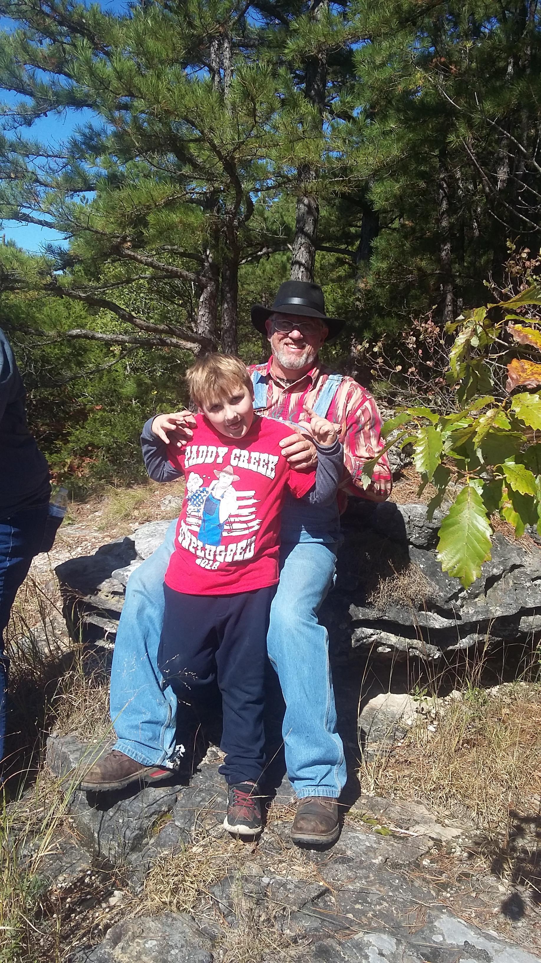 A man and boy sitting on a rock