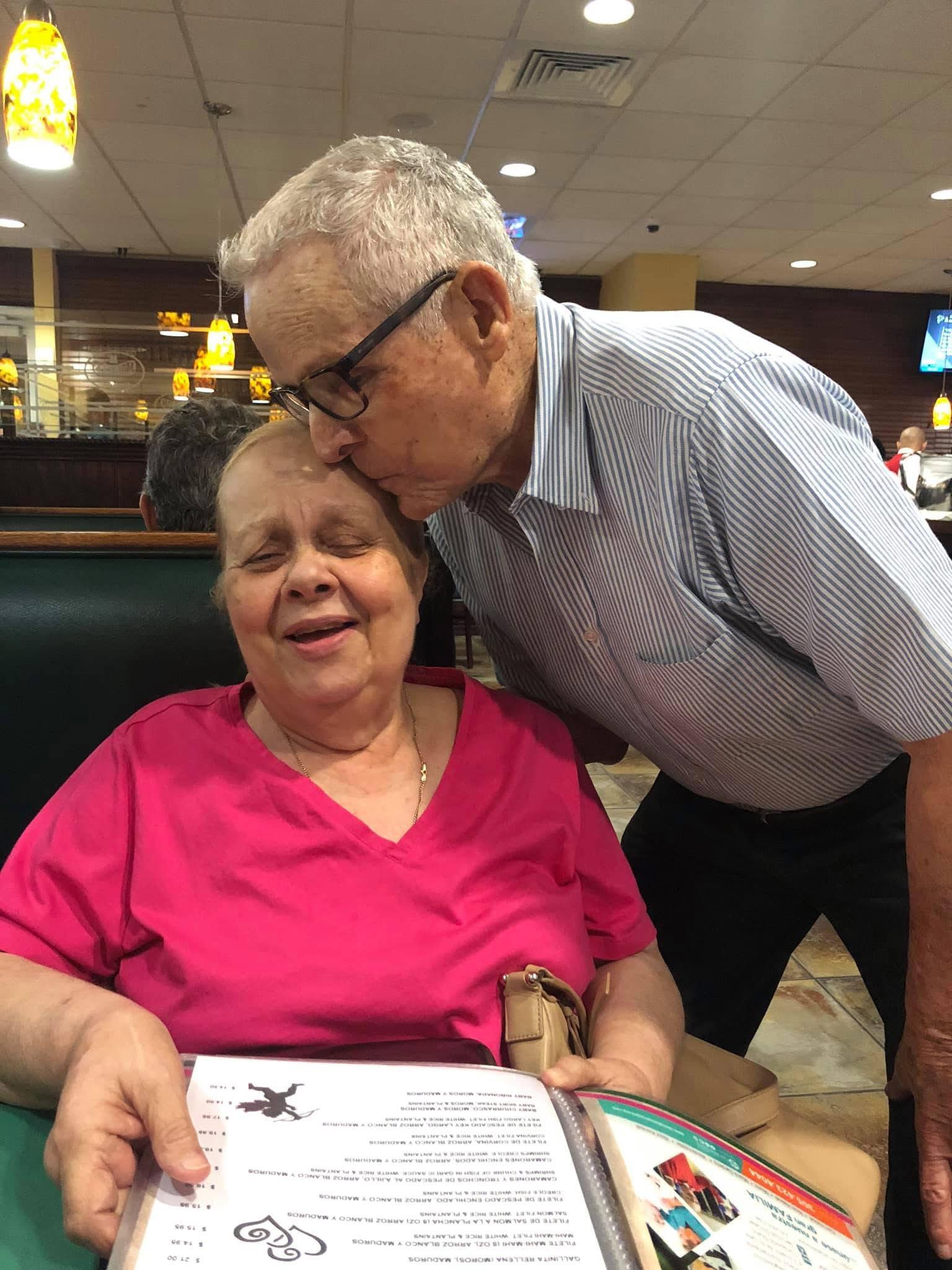 A man kissing a woman's forehead