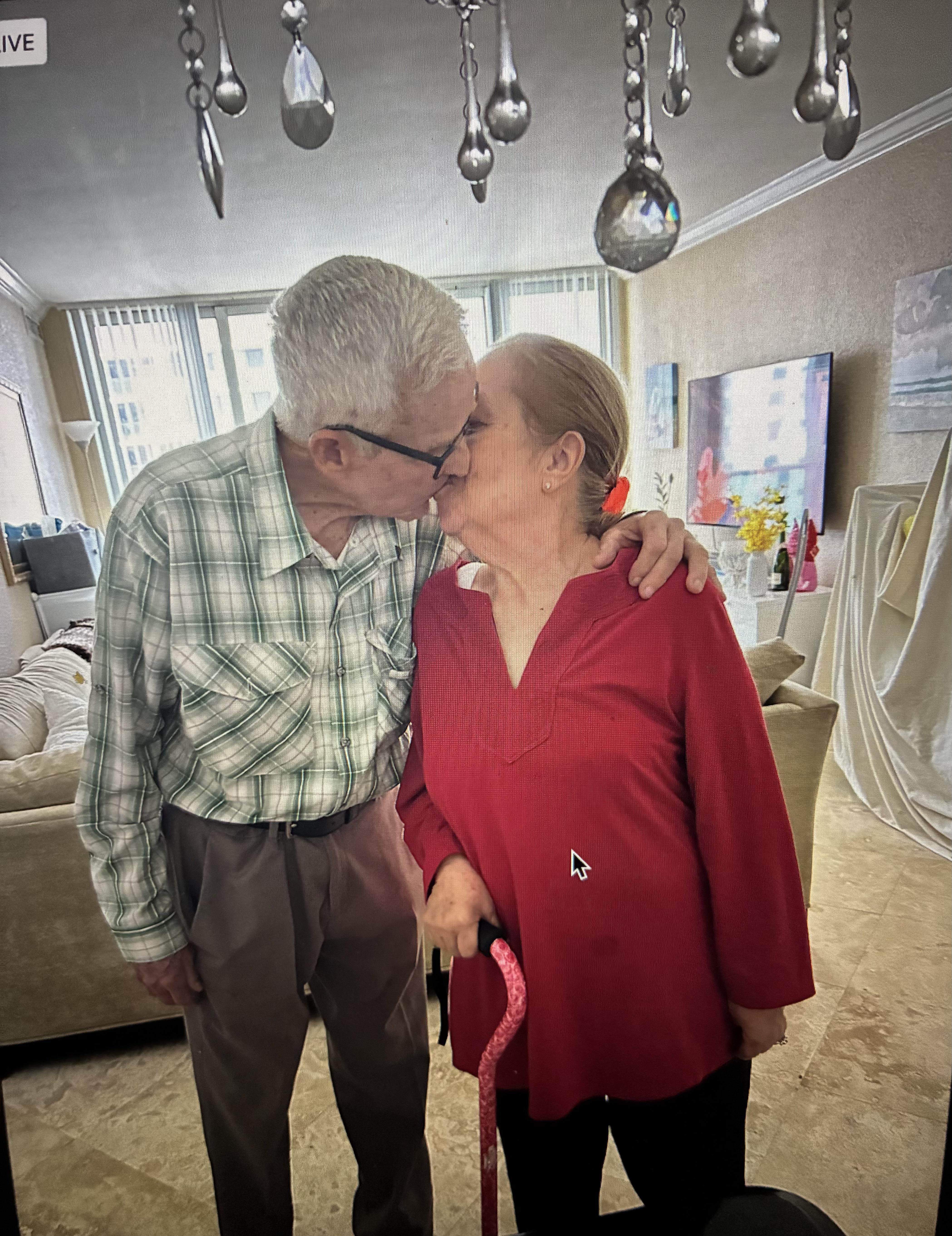 A man and woman kissing in a room