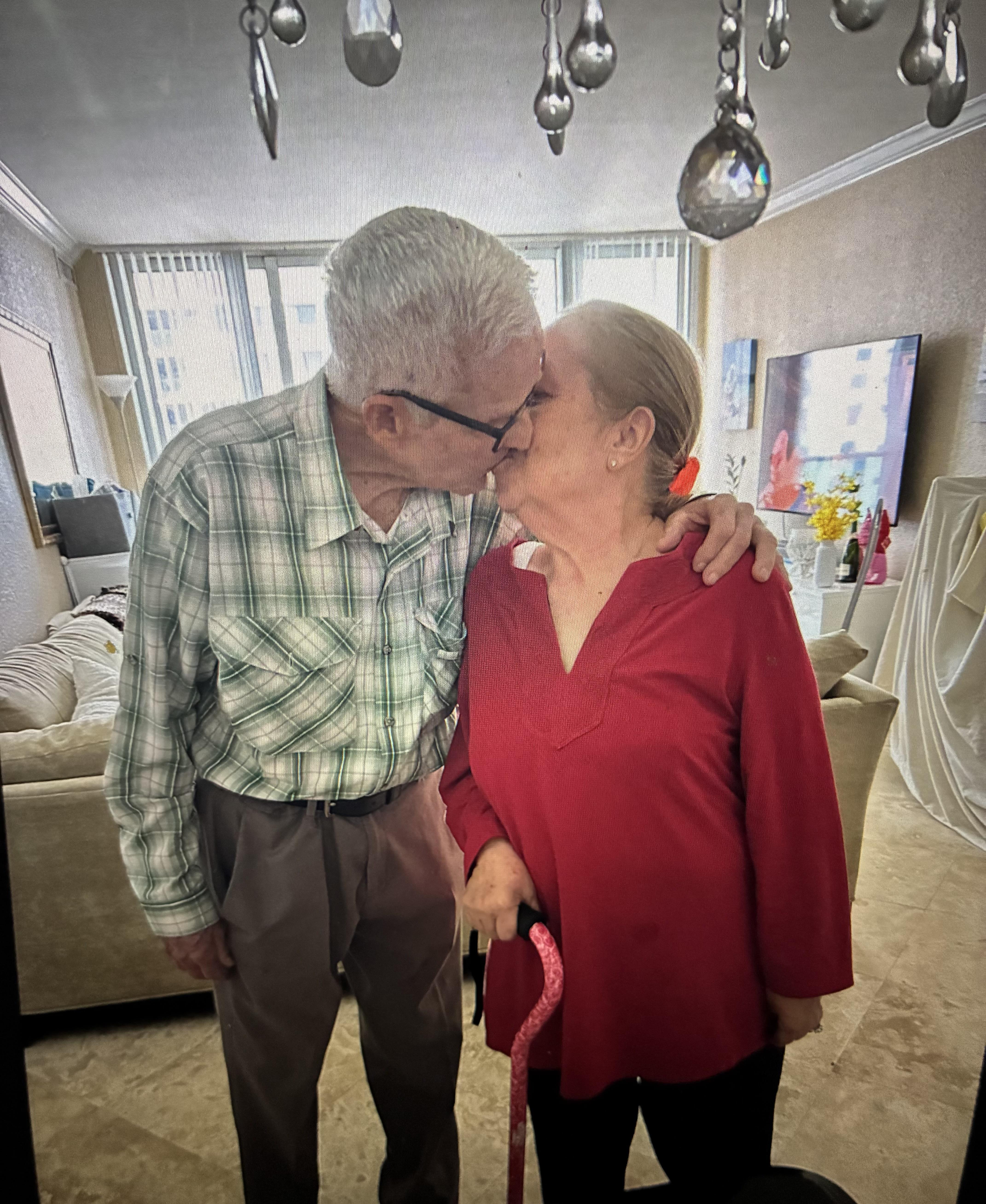 A man and woman kissing in a room