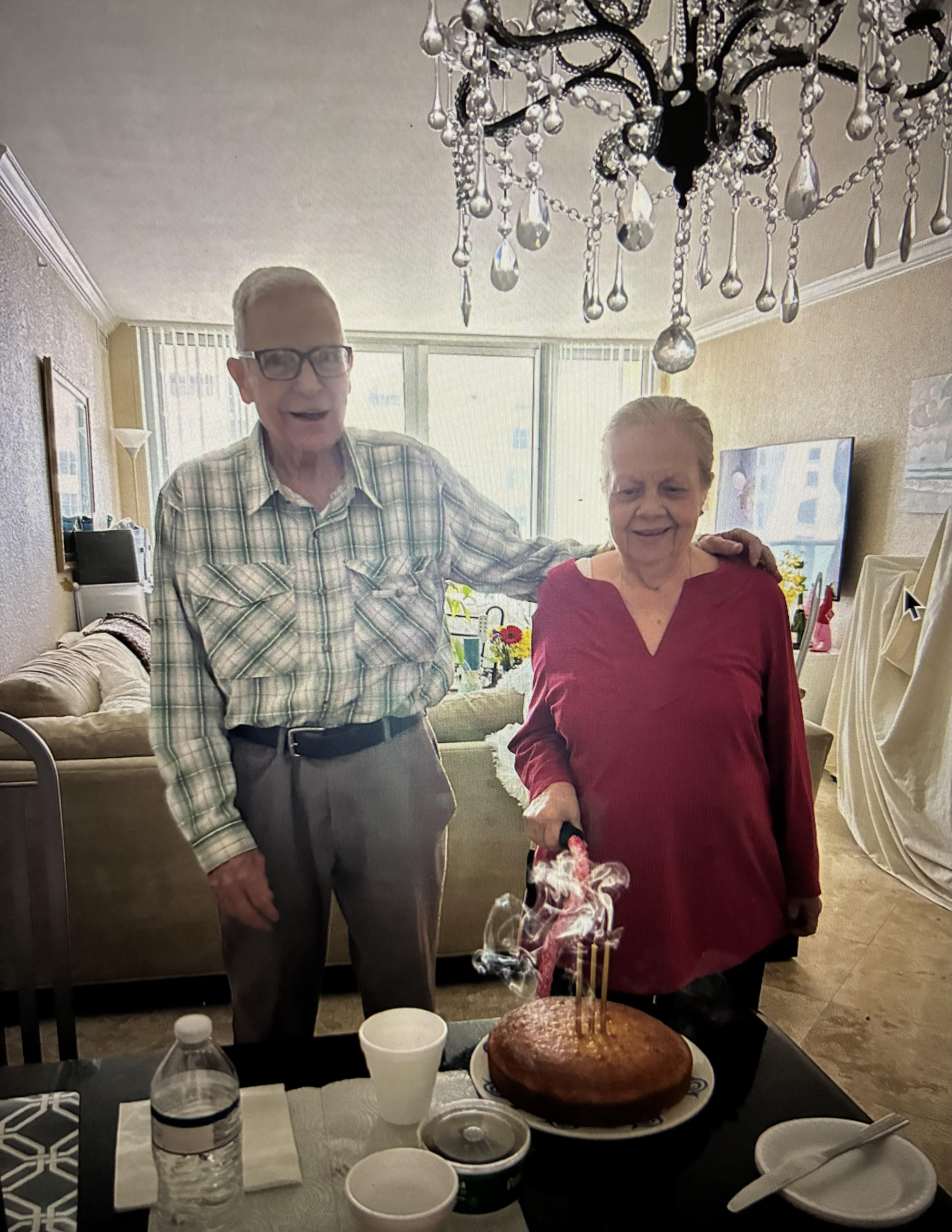 A man and woman standing next to a cake