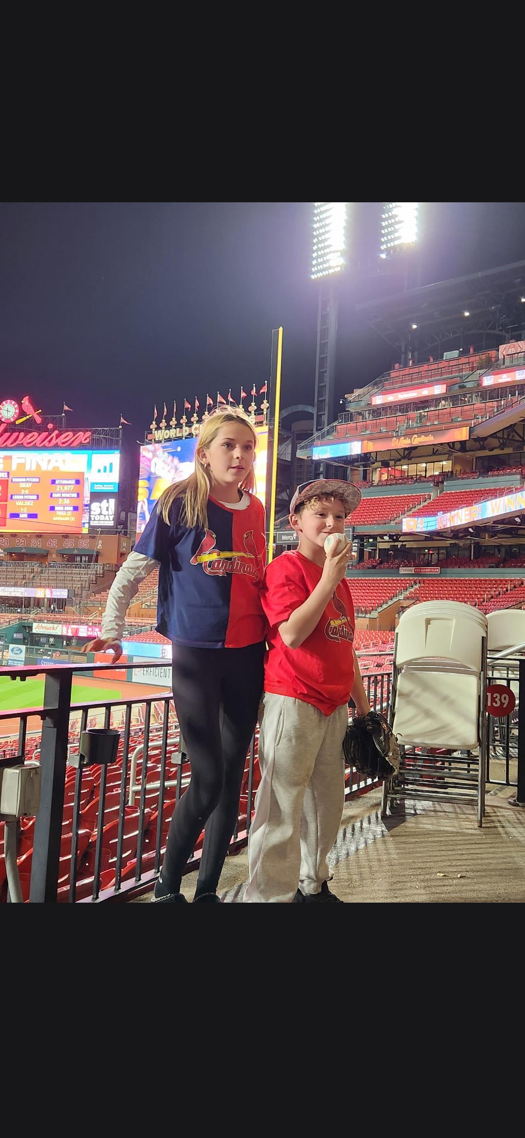 A girl and boy standing in a stadium