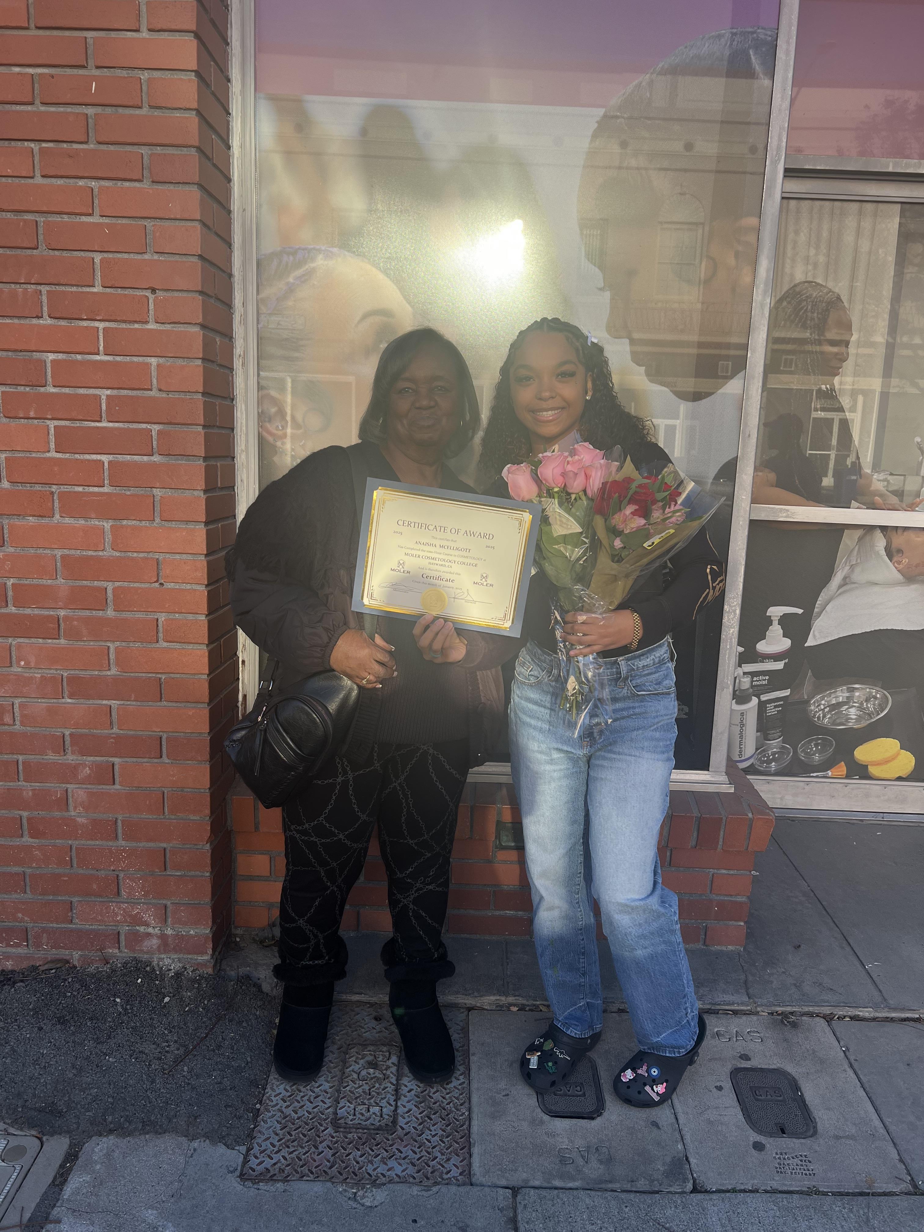 Two women holding flowers and a plaque