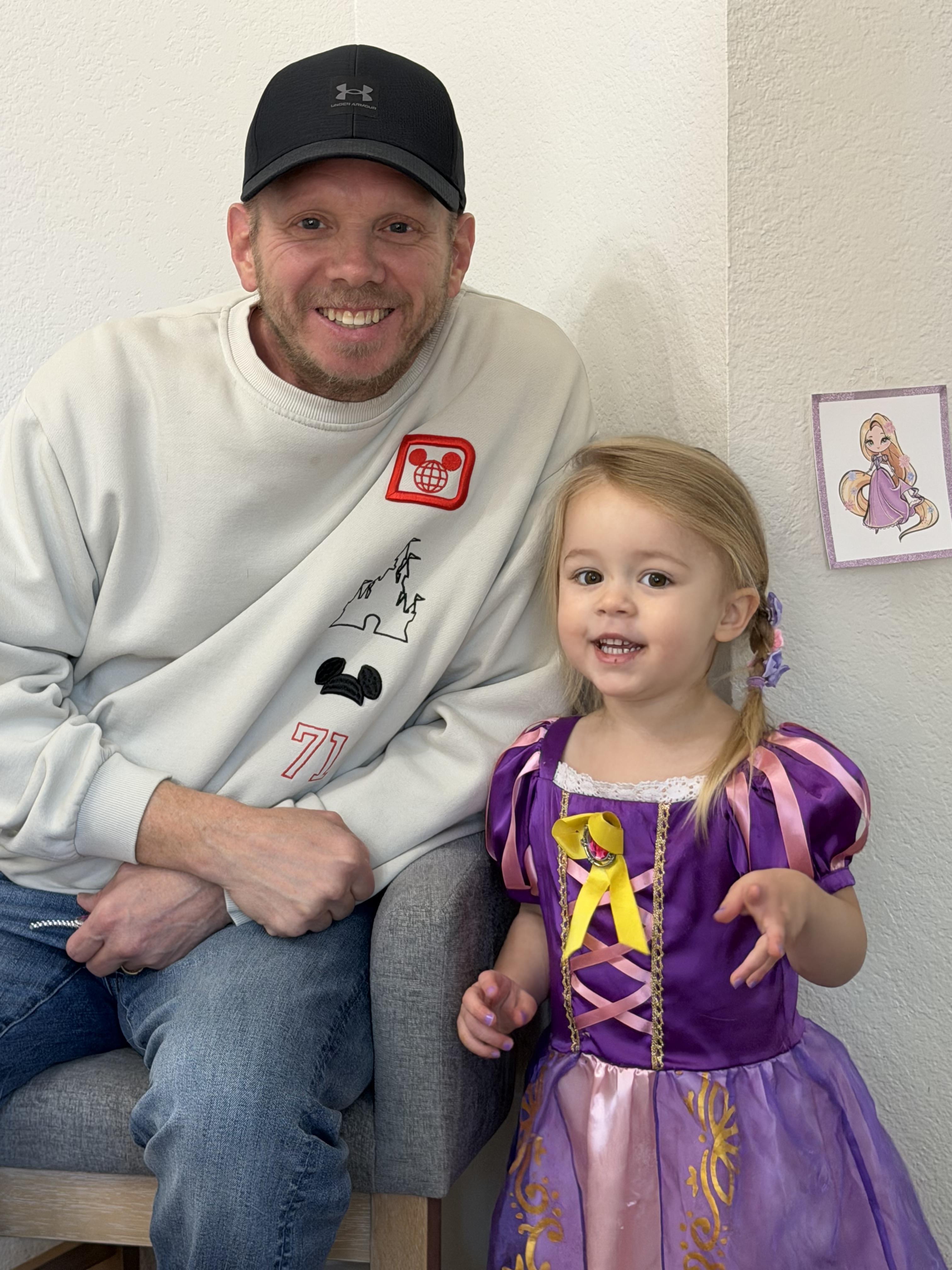 A man and a little girl posing for a picture