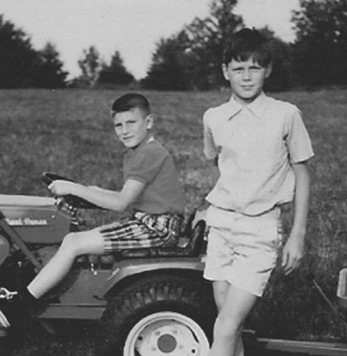 A couple of boys sitting on a tractor
