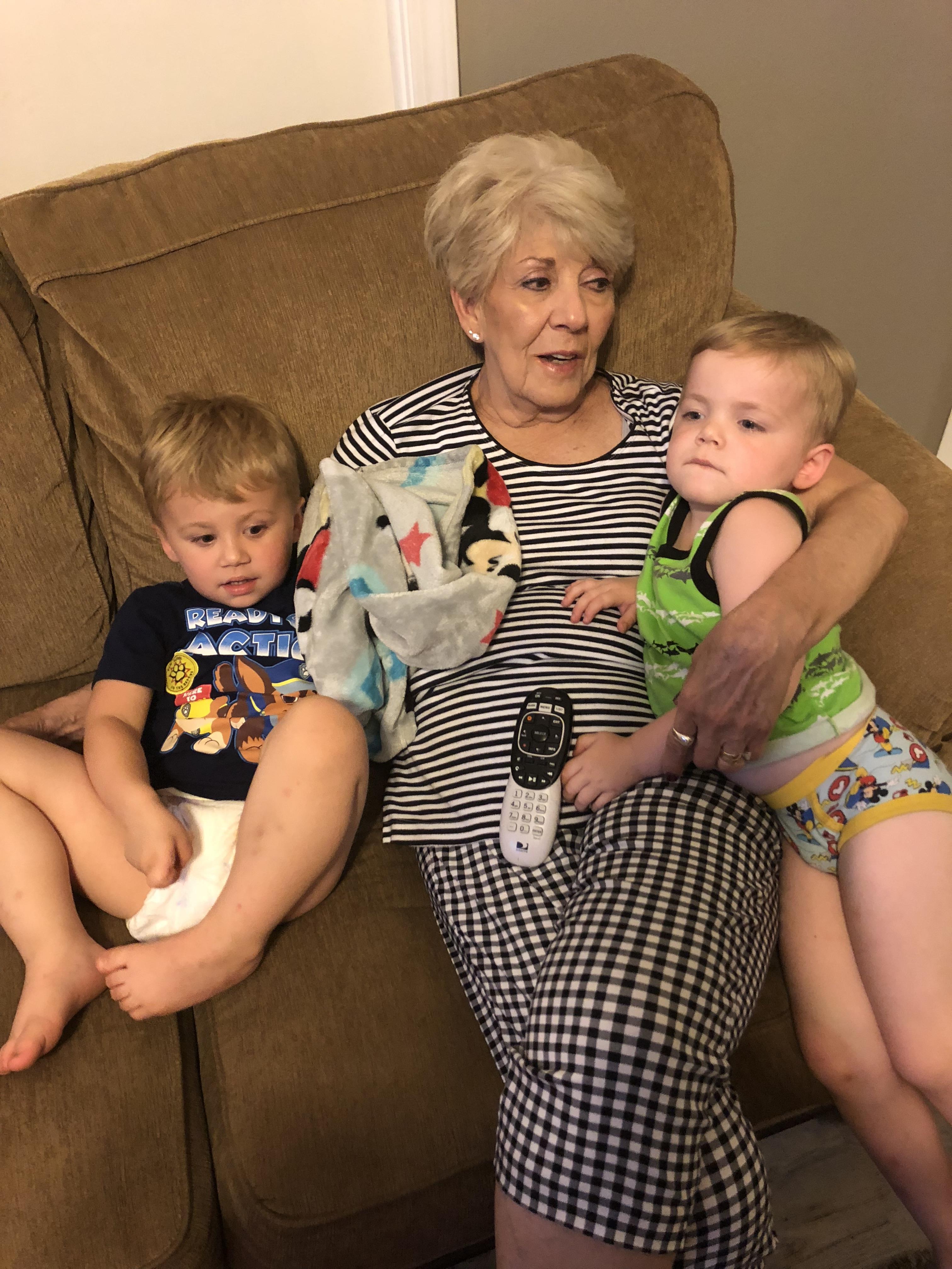 A woman and two boys sitting on a couch