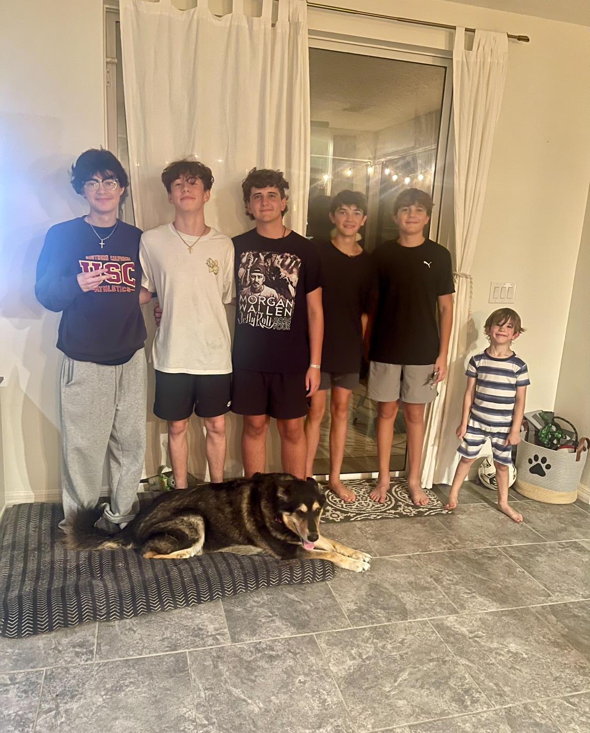 A group of boys and a dog posing for a photo