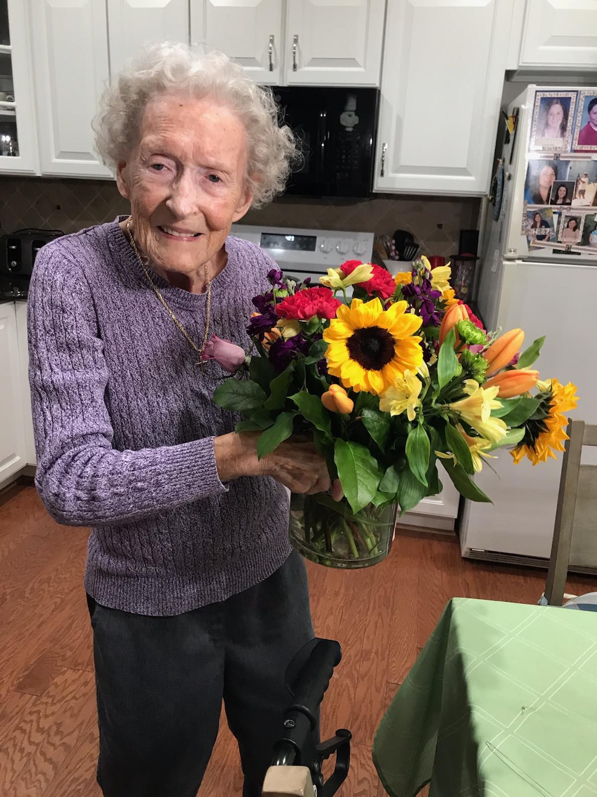 An old woman holding a bouquet of flowers