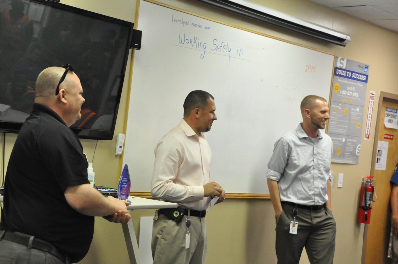 A group of men standing in front of a whiteboard