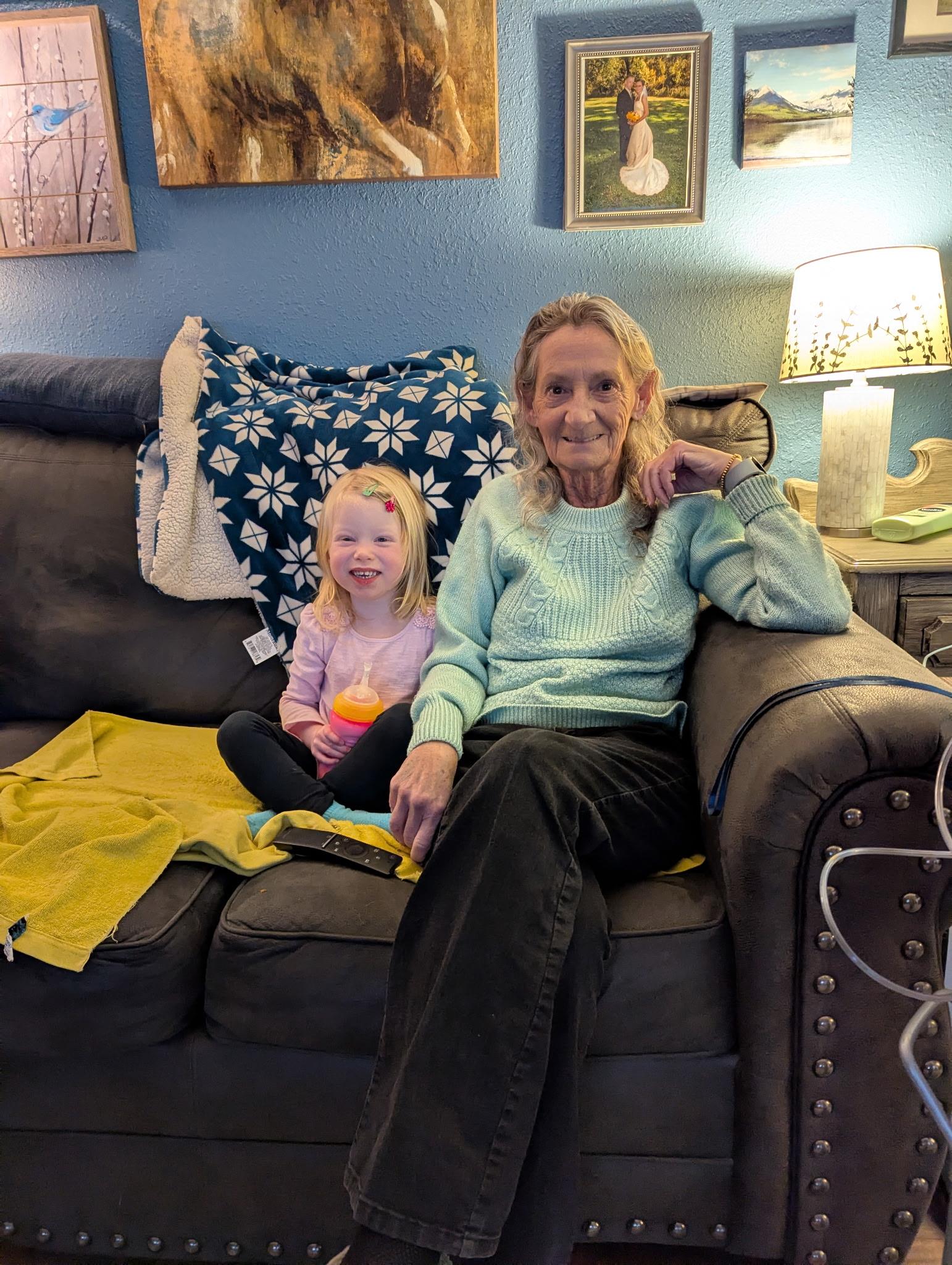 A woman and a girl sitting on a couch