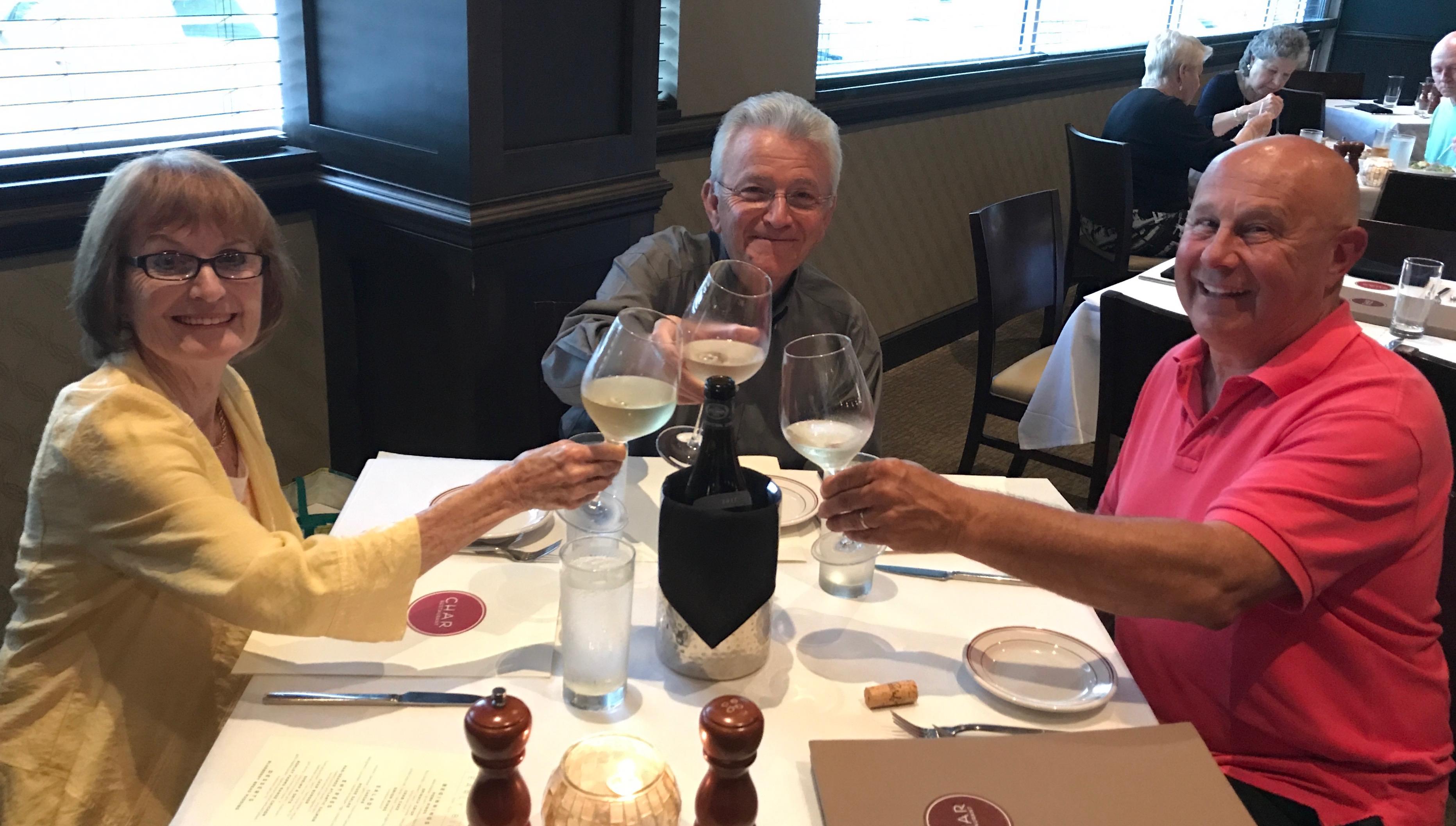 A group of people sitting at a table with wine glasses