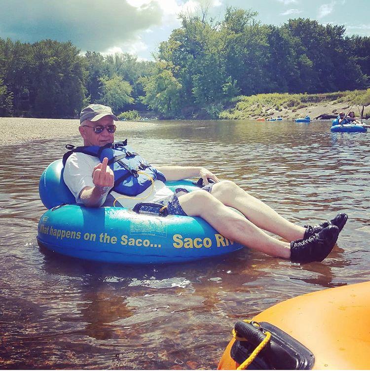 A man in a blue float on a river