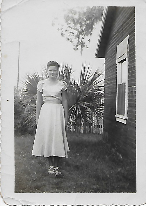 A woman standing in front of a house