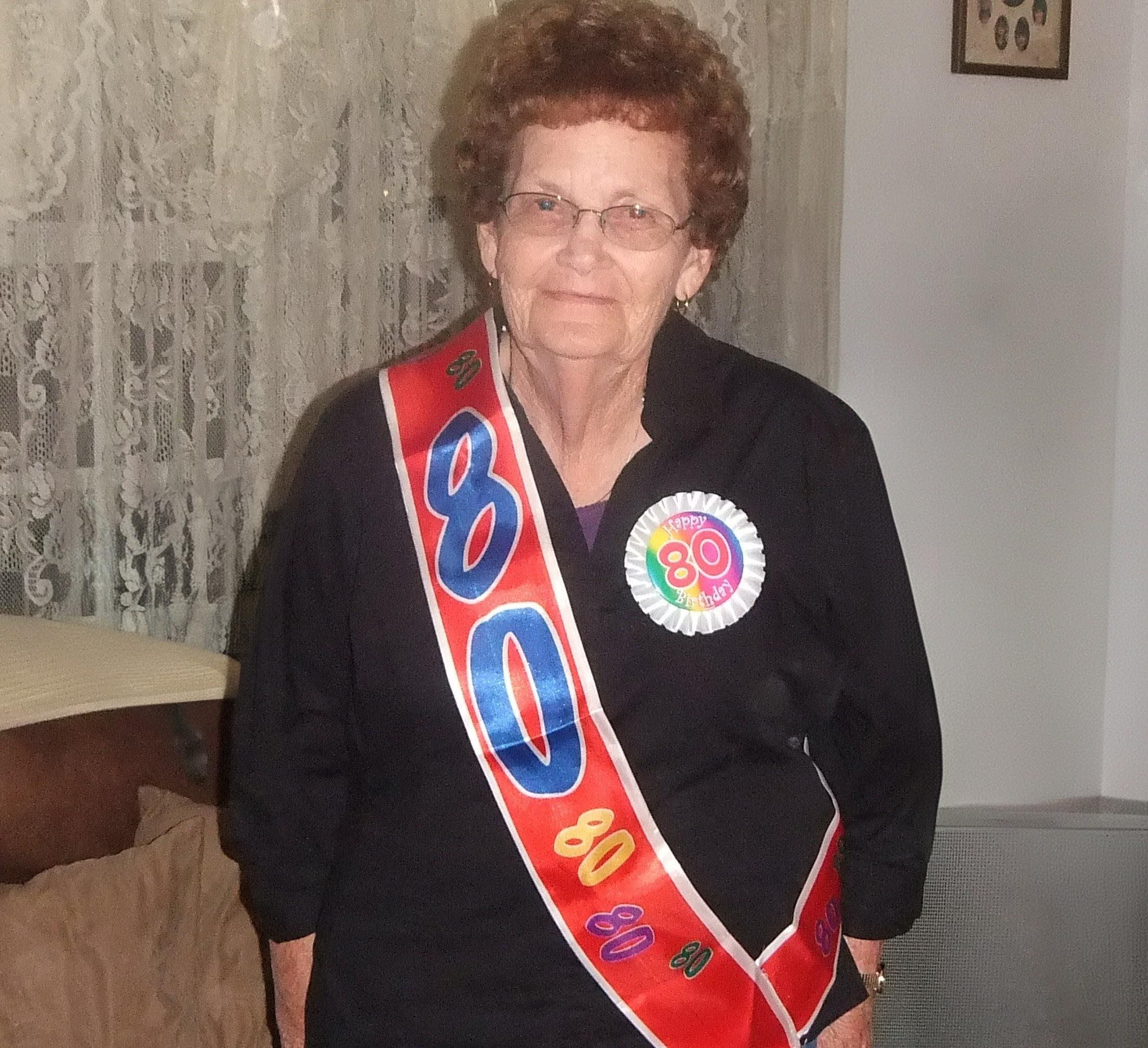 An older woman wearing a sash