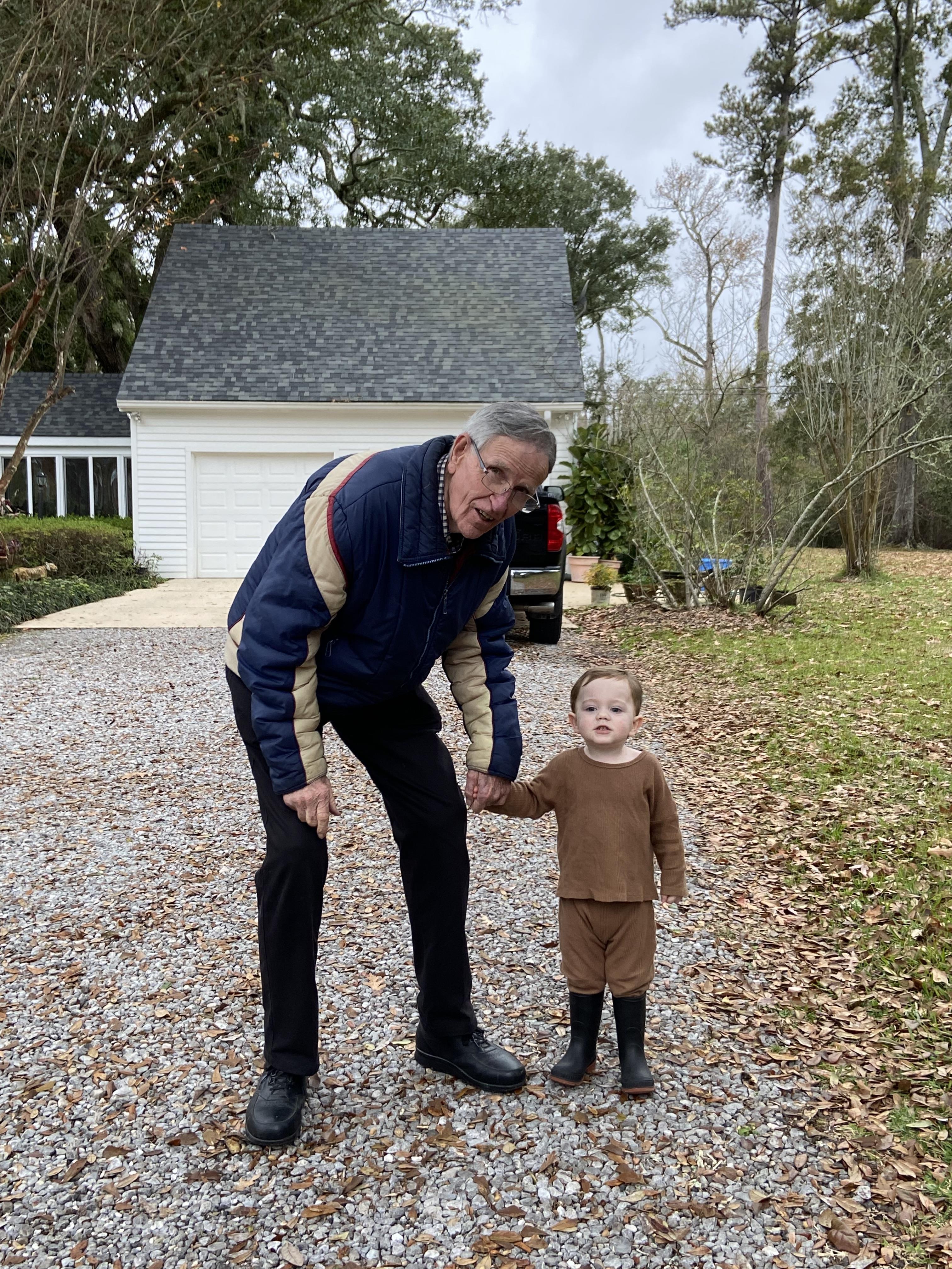 An old man holding a child's hand