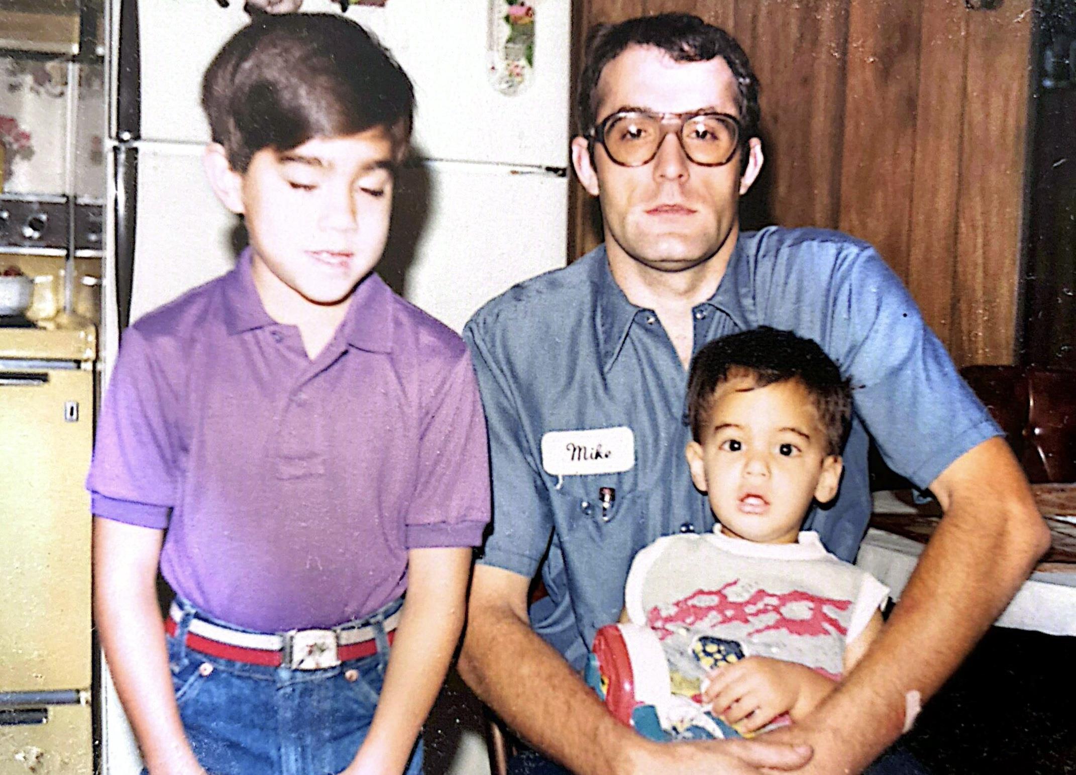 A man holding two boys