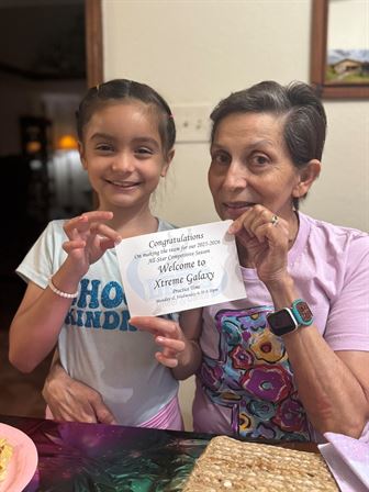 A woman and a girl holding a paper