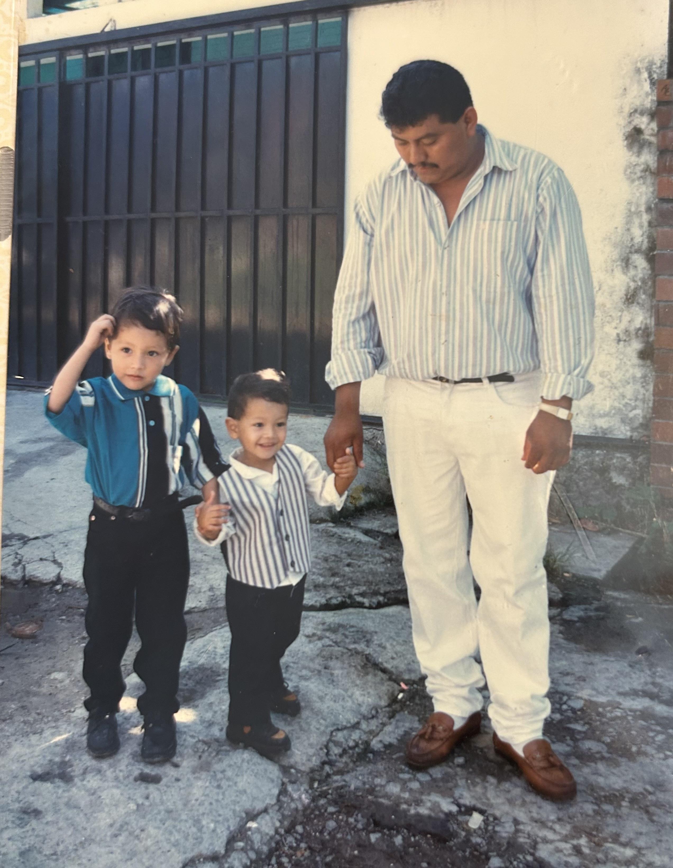 A man and two boys standing outside