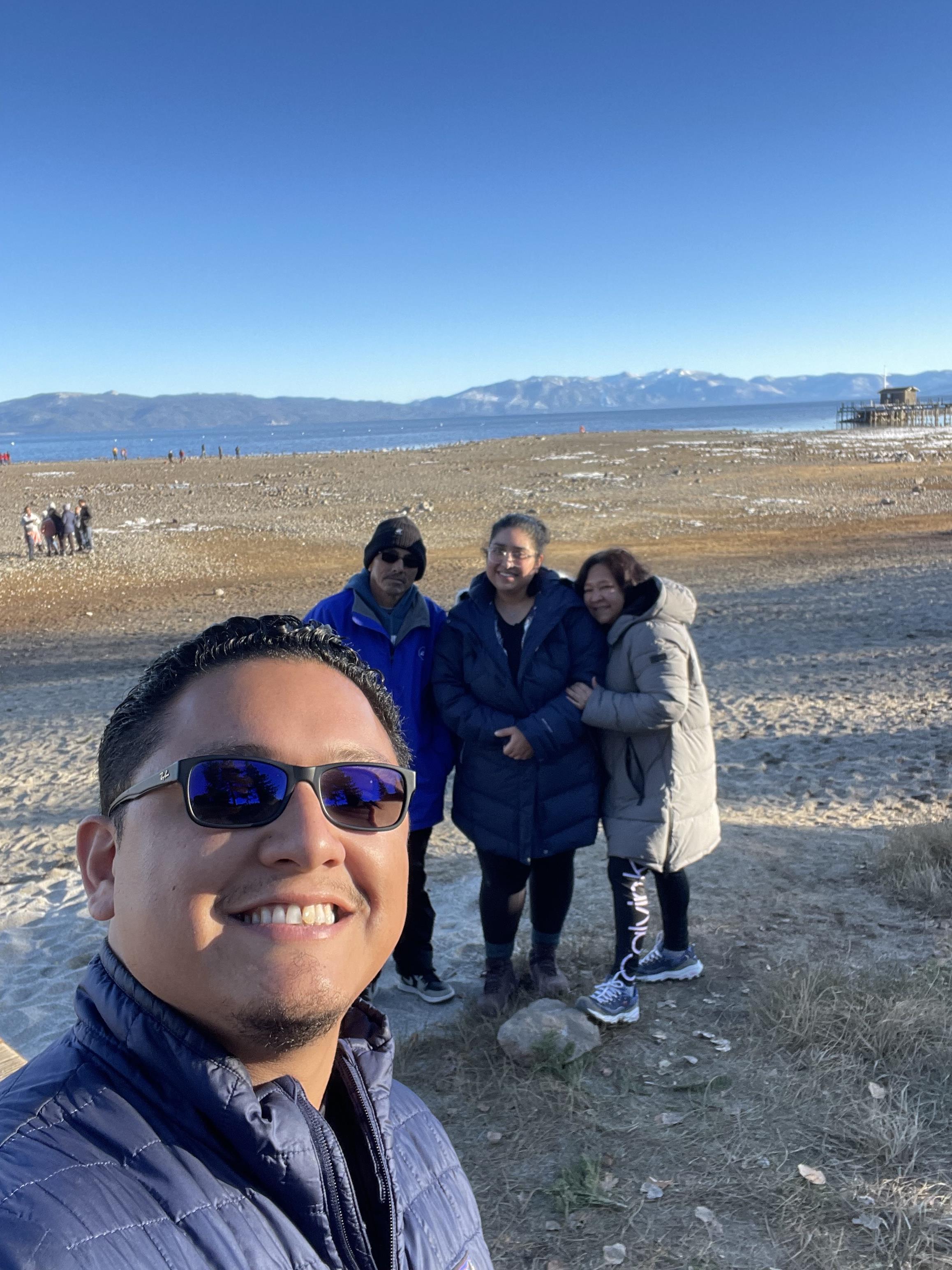 A man taking a selfie with people in the background