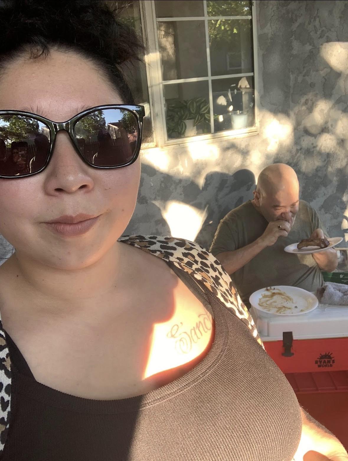 A woman taking a selfie with a man eating