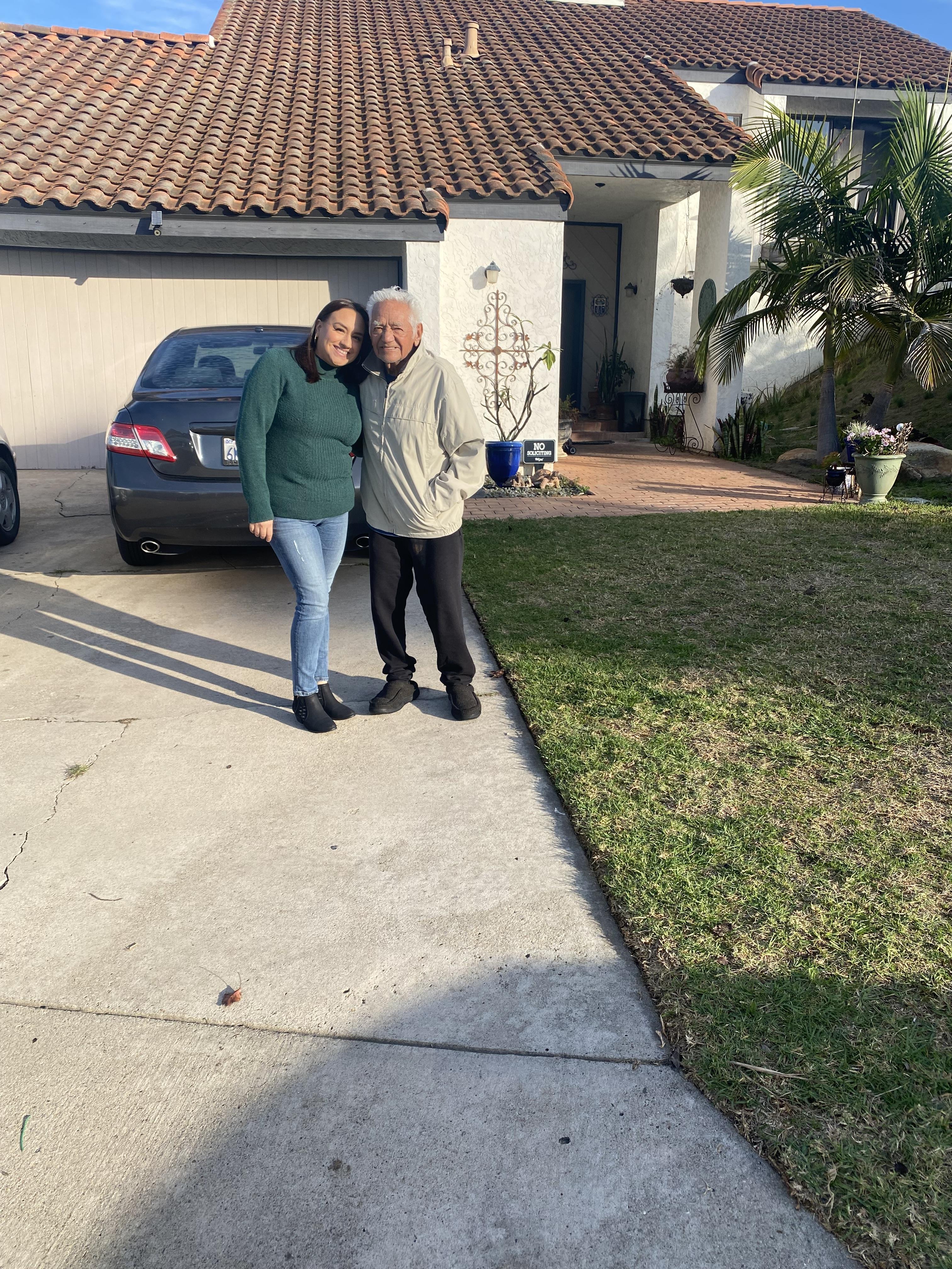 A man and woman standing in front of a house