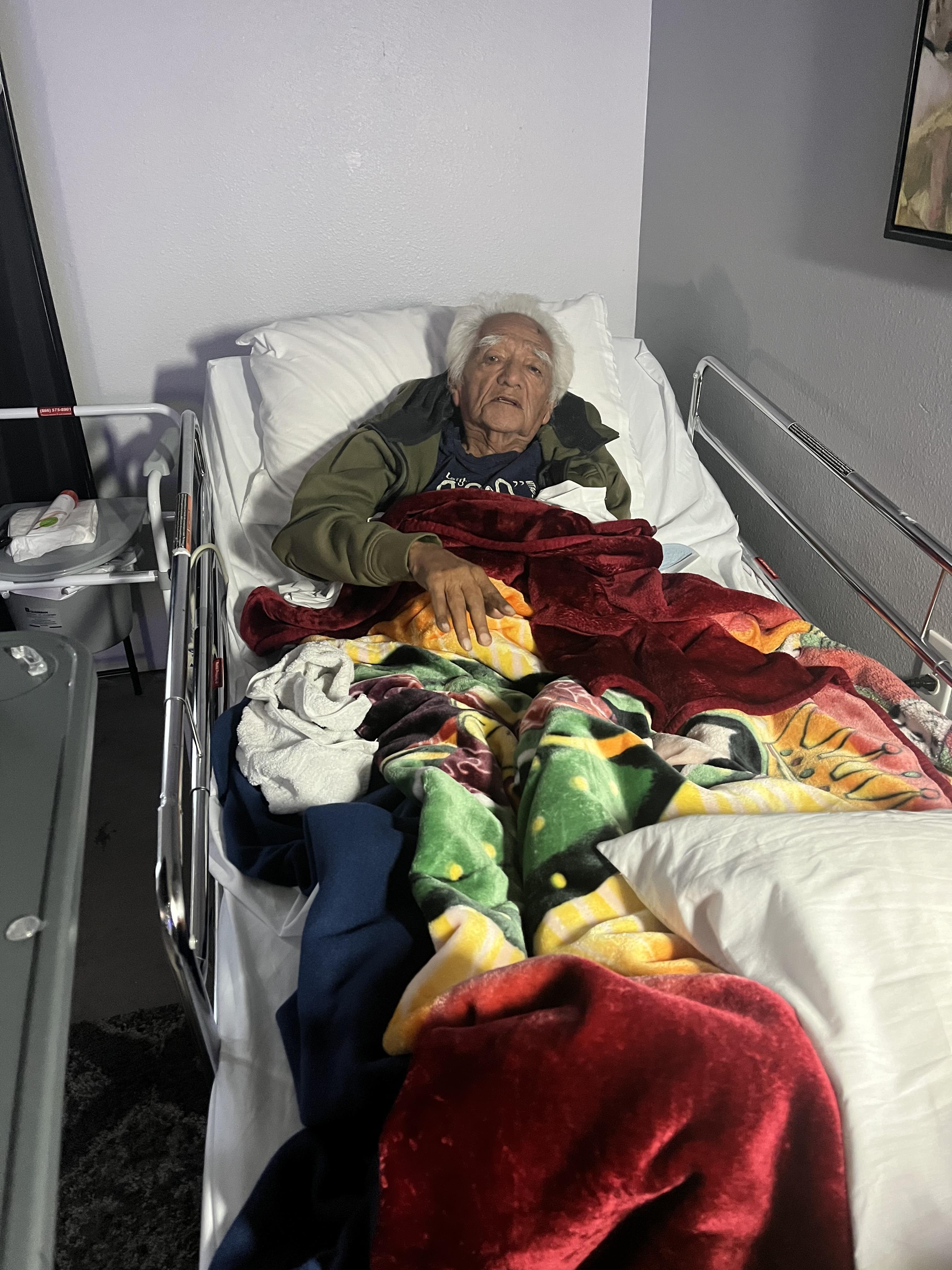An old woman lying in a hospital bed