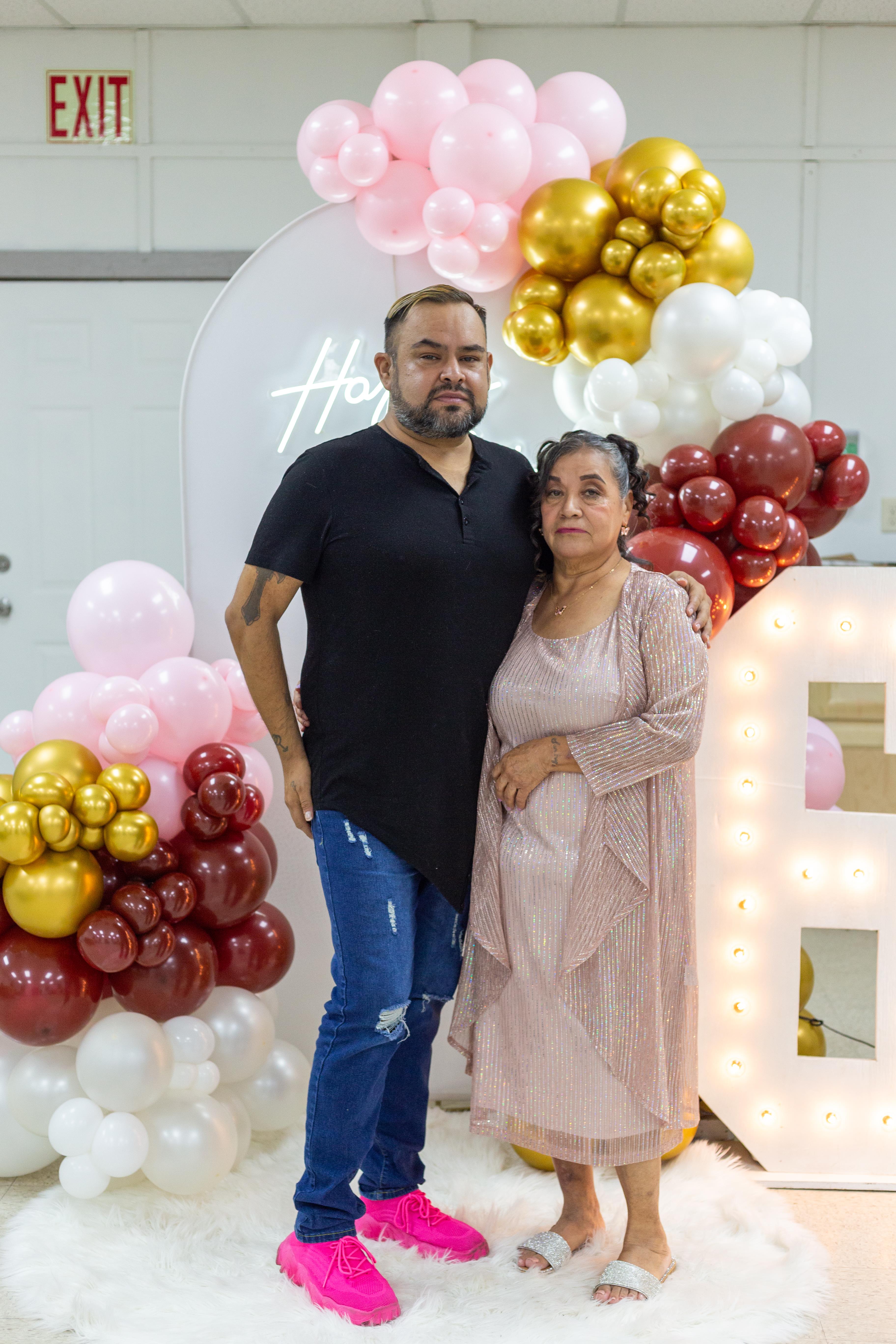 A man and woman standing next to balloons