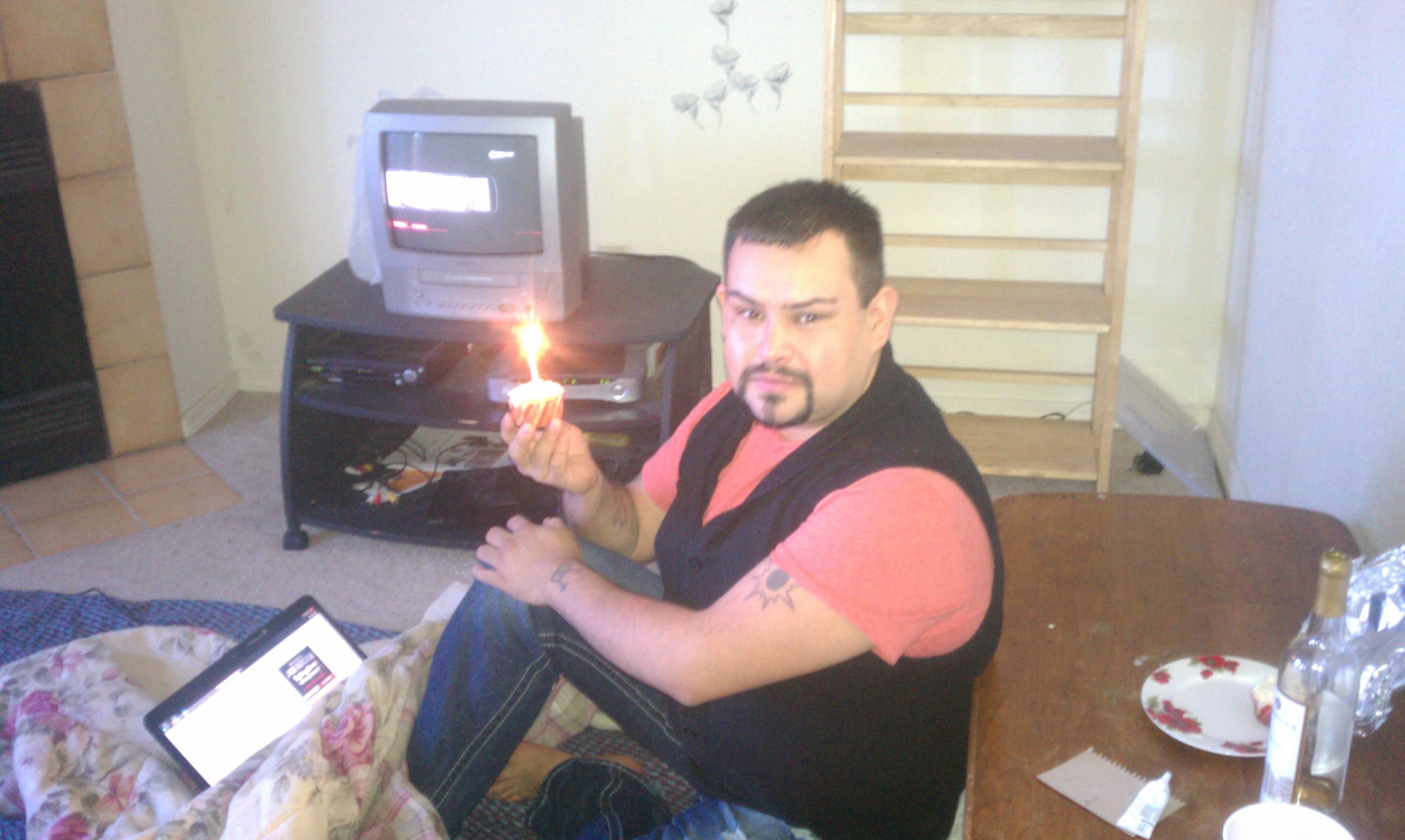 A man sitting on a bed holding a lit match
