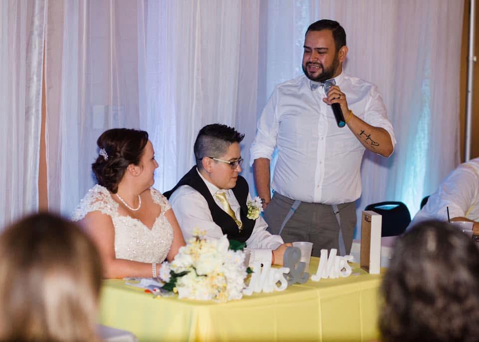 A man in a white shirt speaking into a microphone