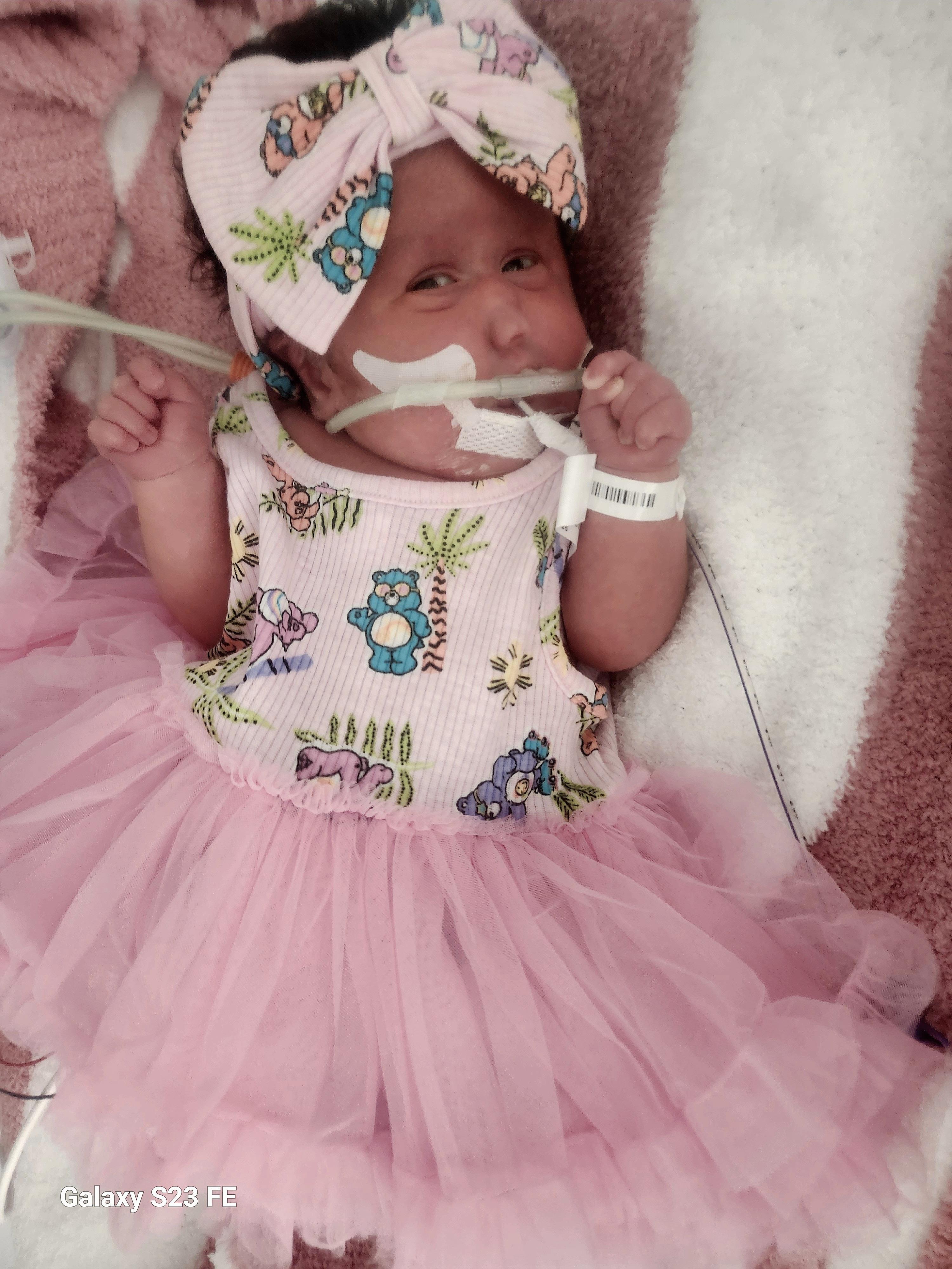 A baby in a tutu and a bow