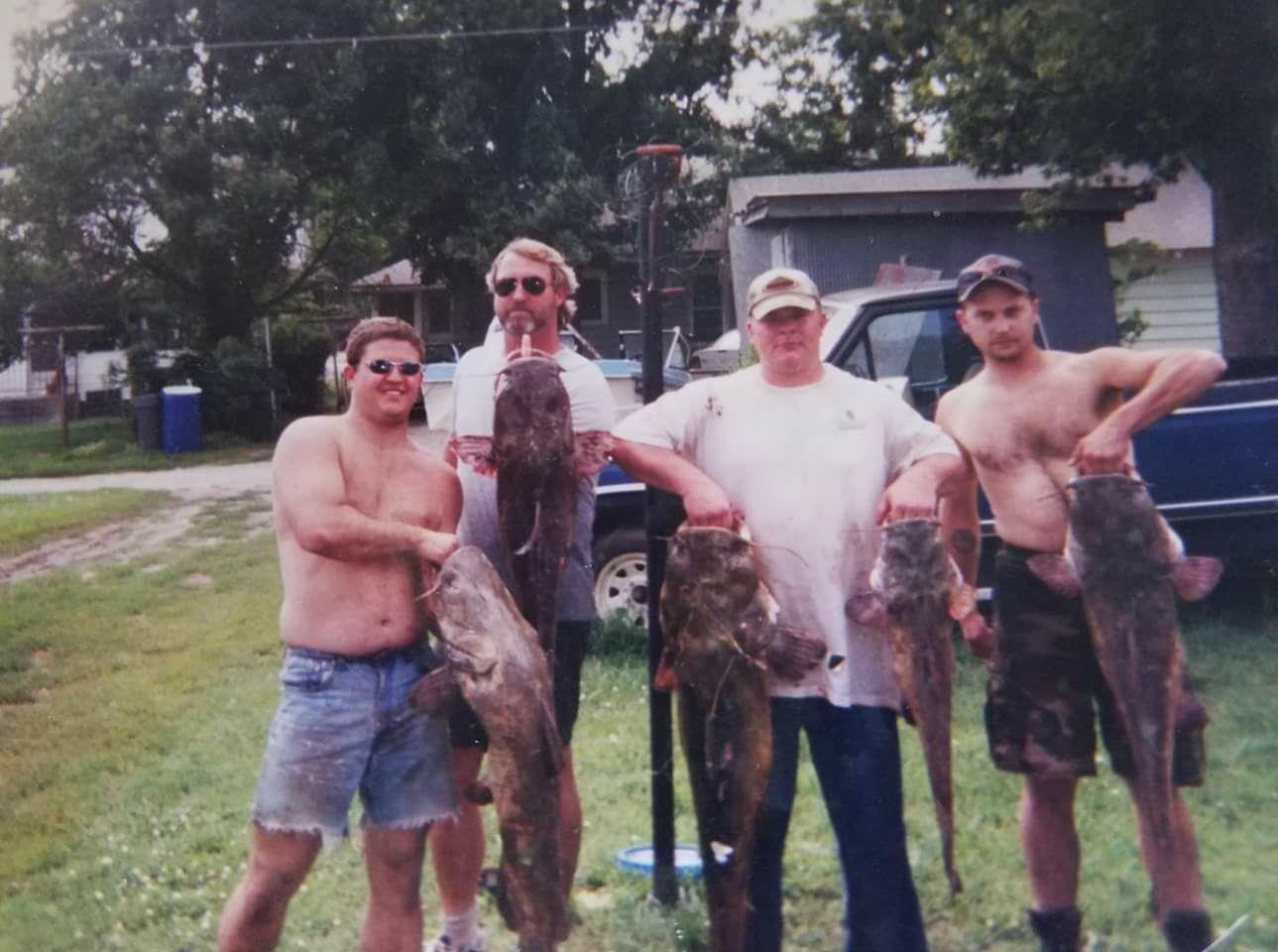 A group of men holding fish