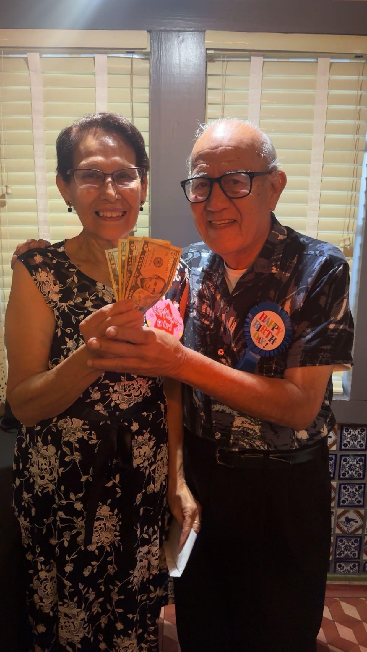A man and woman holding money