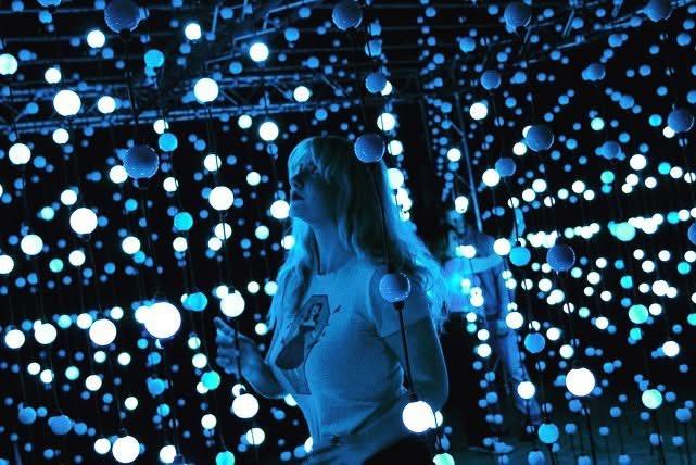 A woman standing in front of many white lights