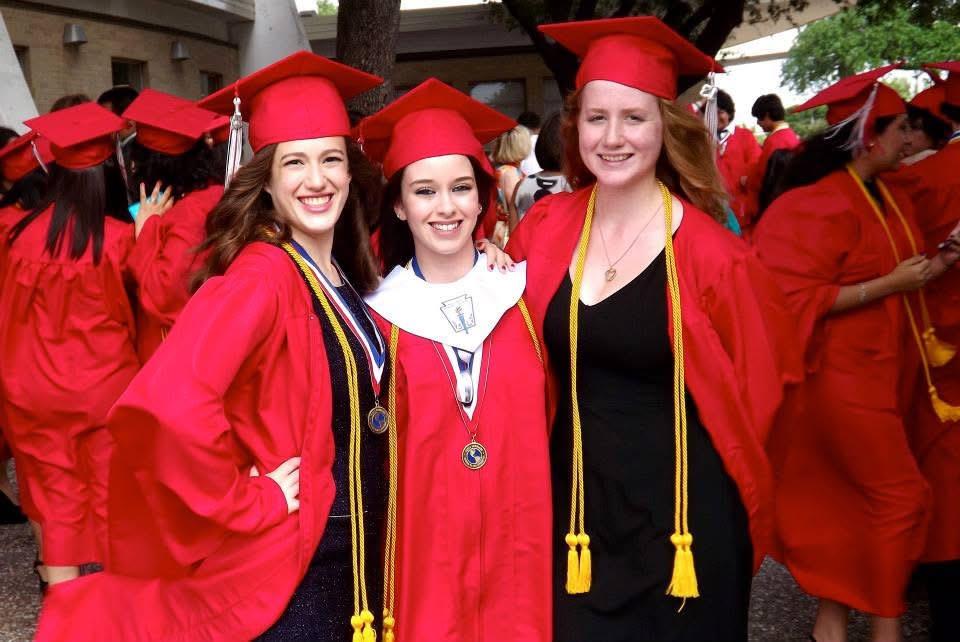 A group of women in red graduation gowns and caps