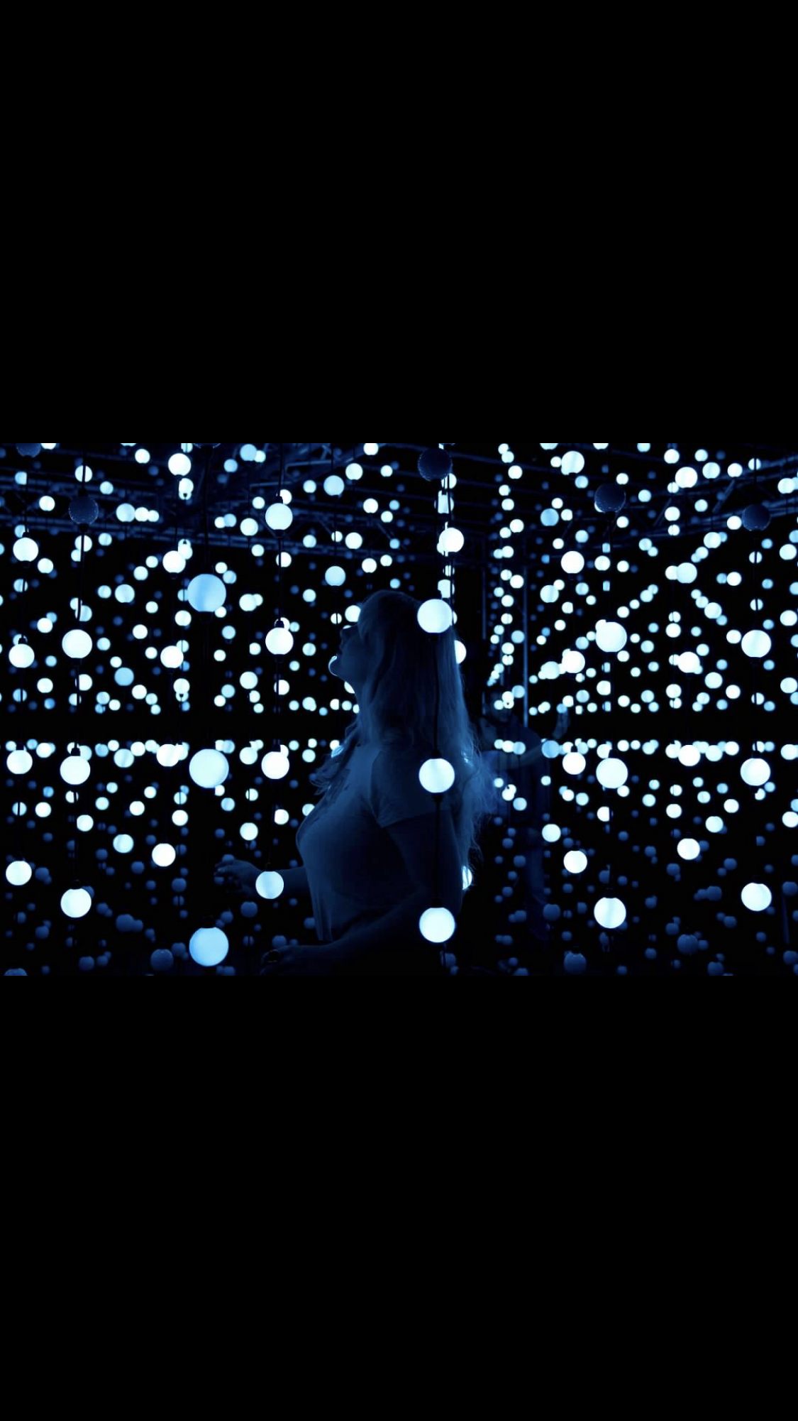 A woman standing in front of many white balls