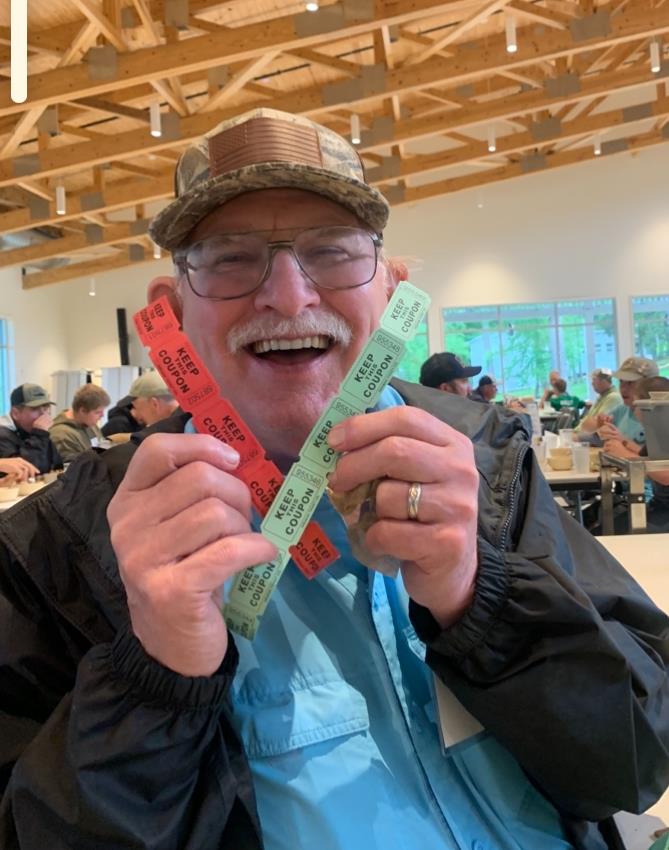 A man holding up colorful tickets