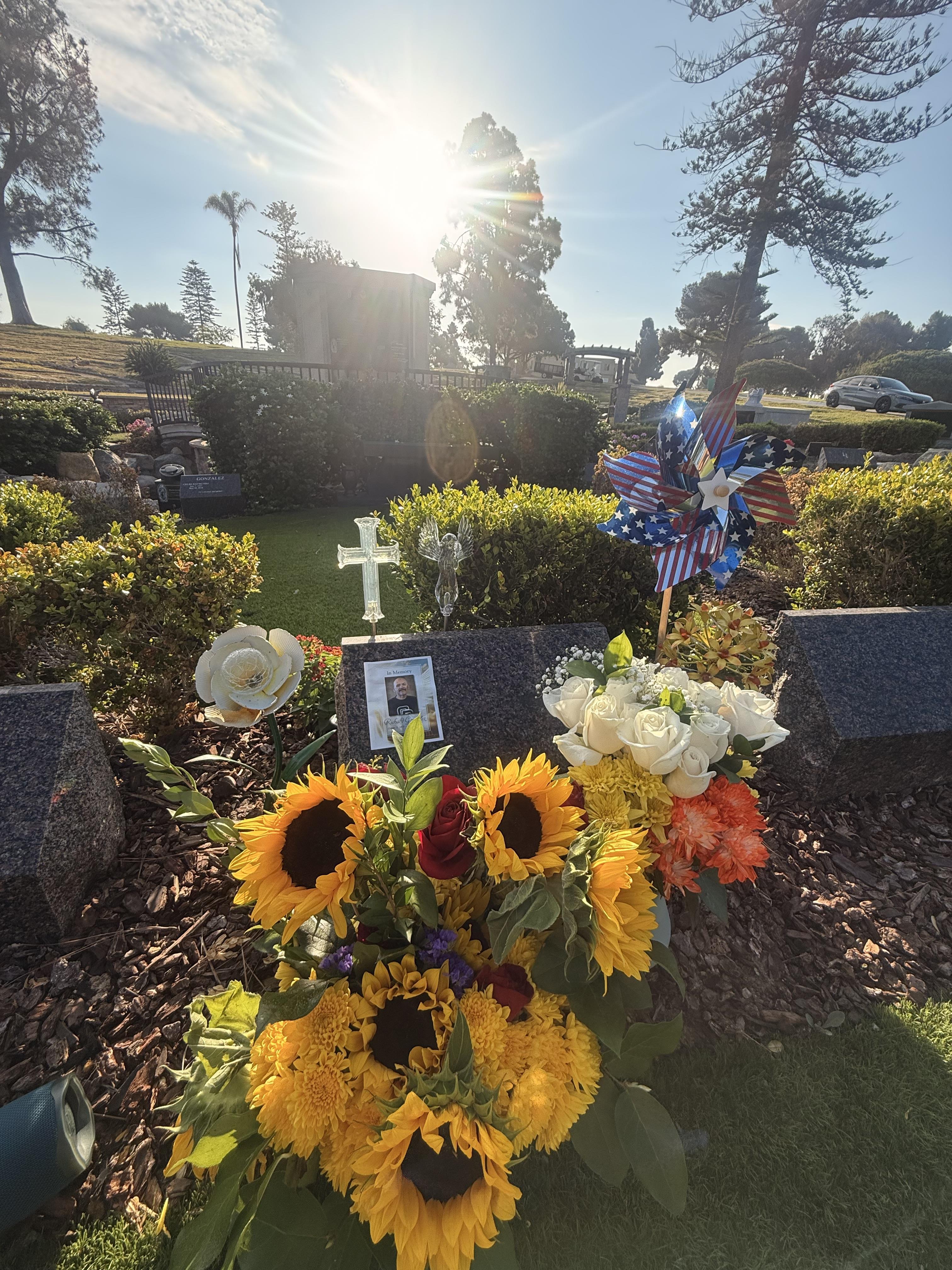 A grave with flowers and a pinwheel