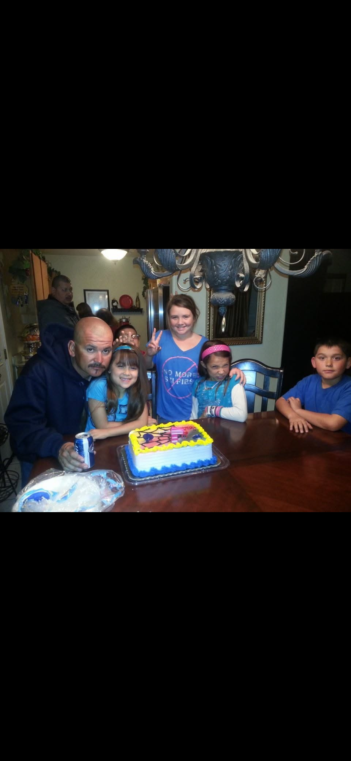 A group of people sitting at a table with a cake