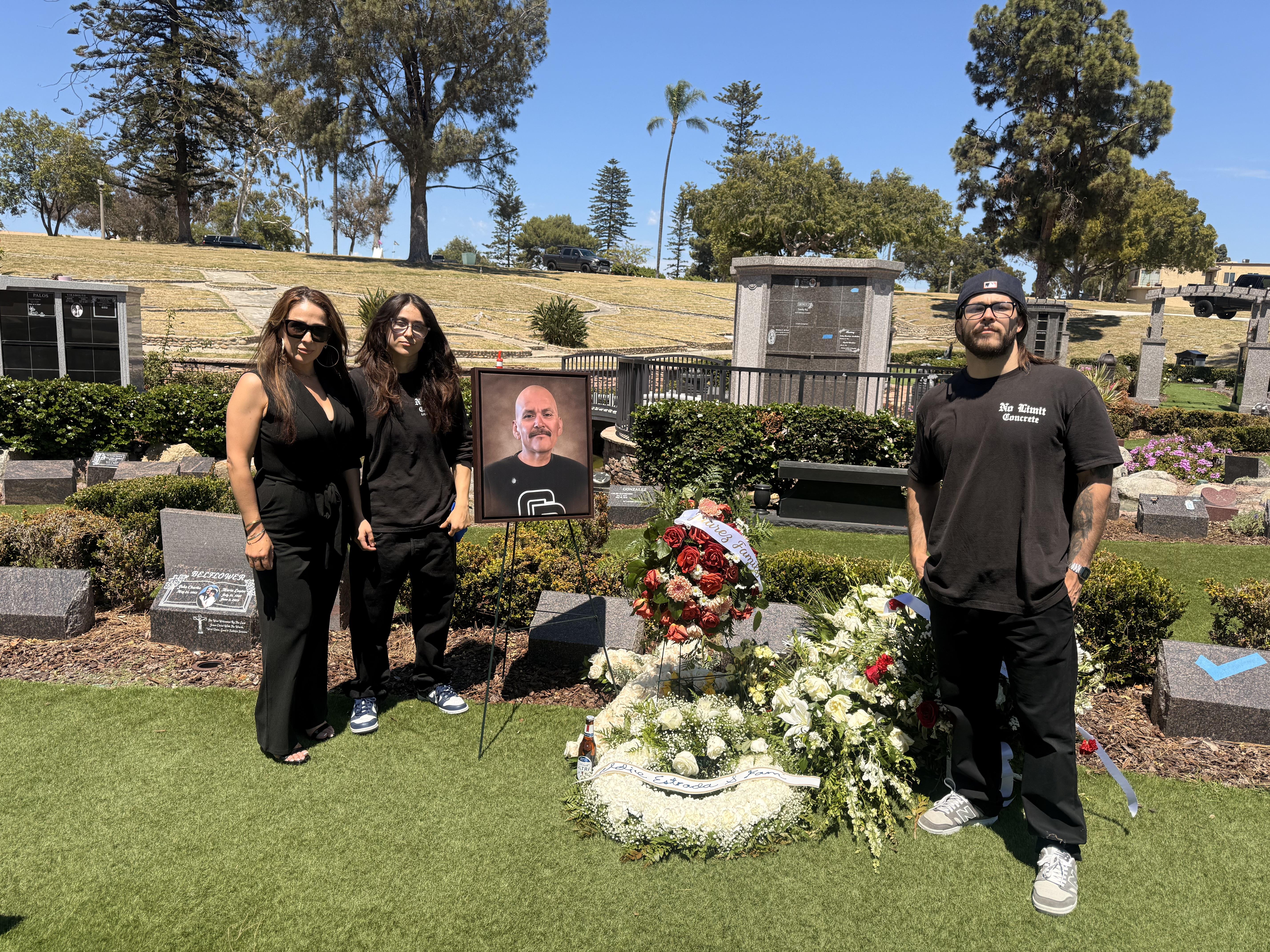 A group of people standing in front of a grave