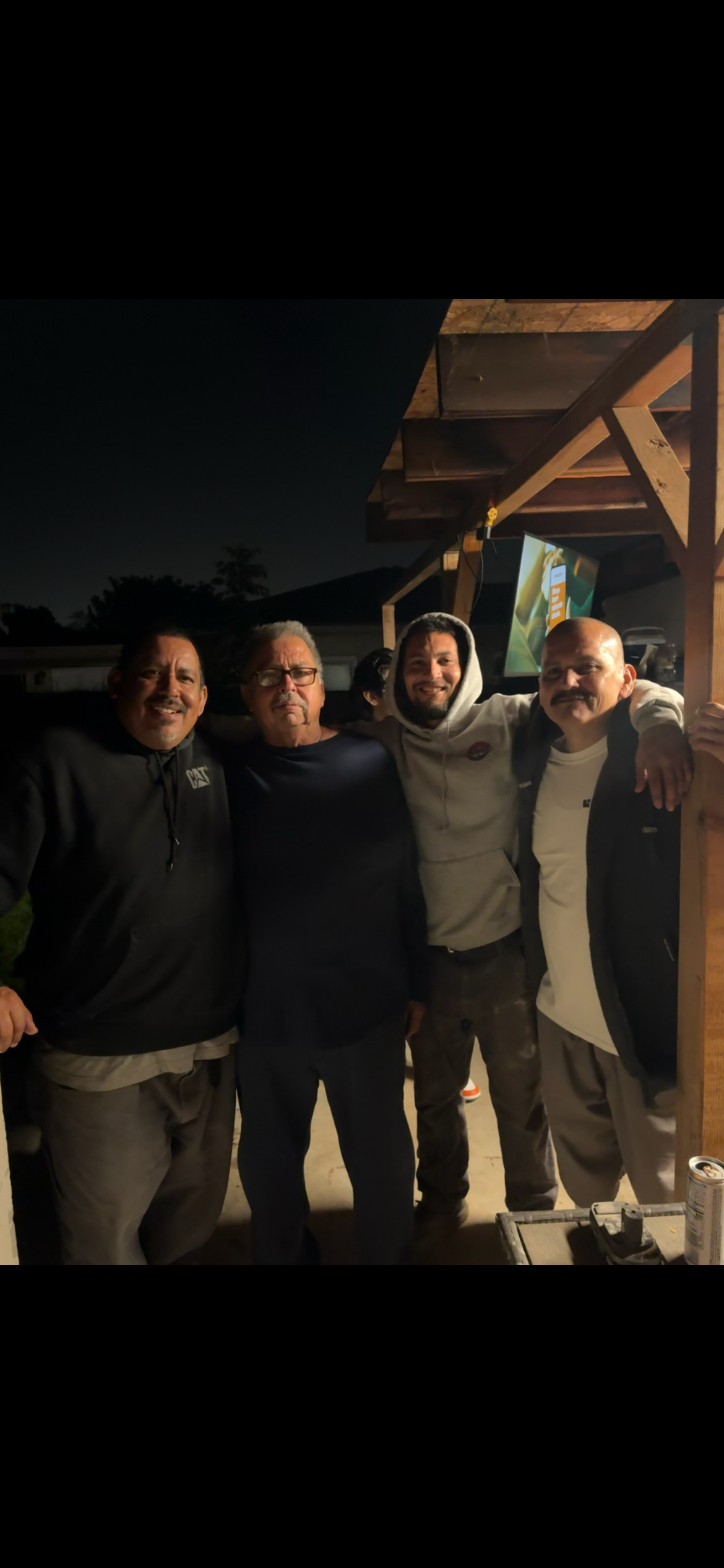 A group of men standing together outside at night