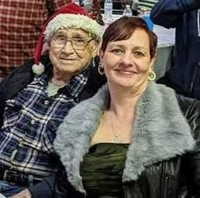A woman with a fur coat and a woman with a santa hat