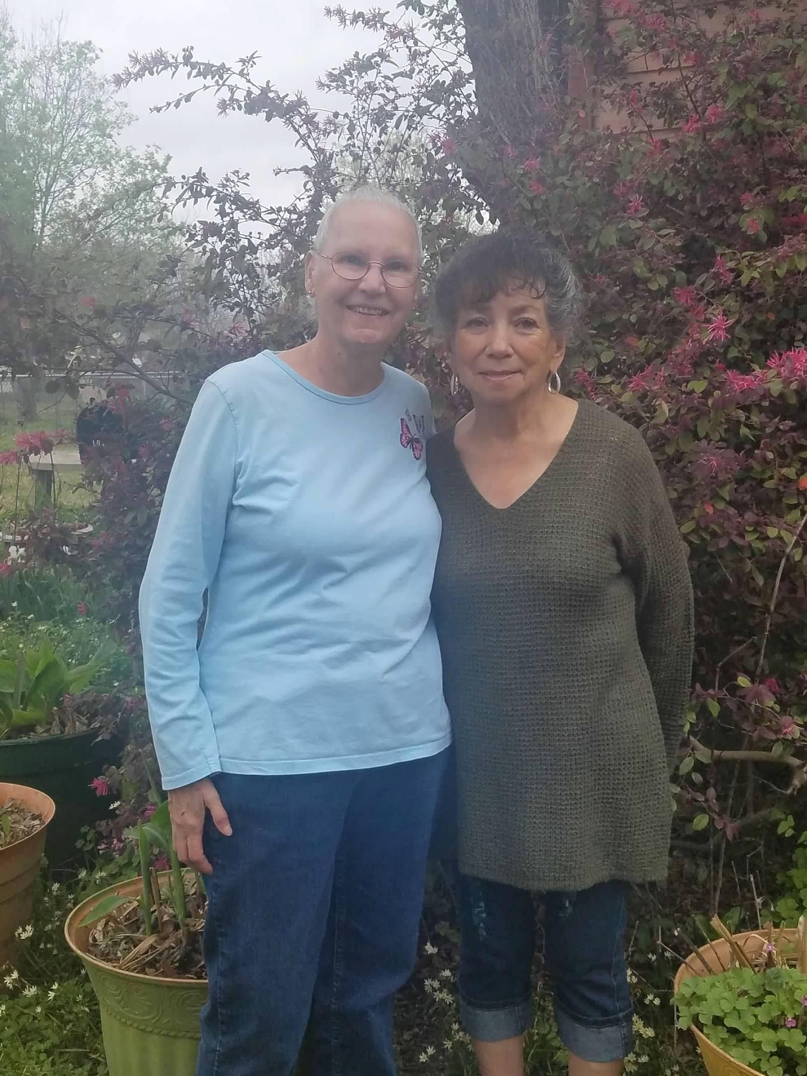 Two women standing together in a garden