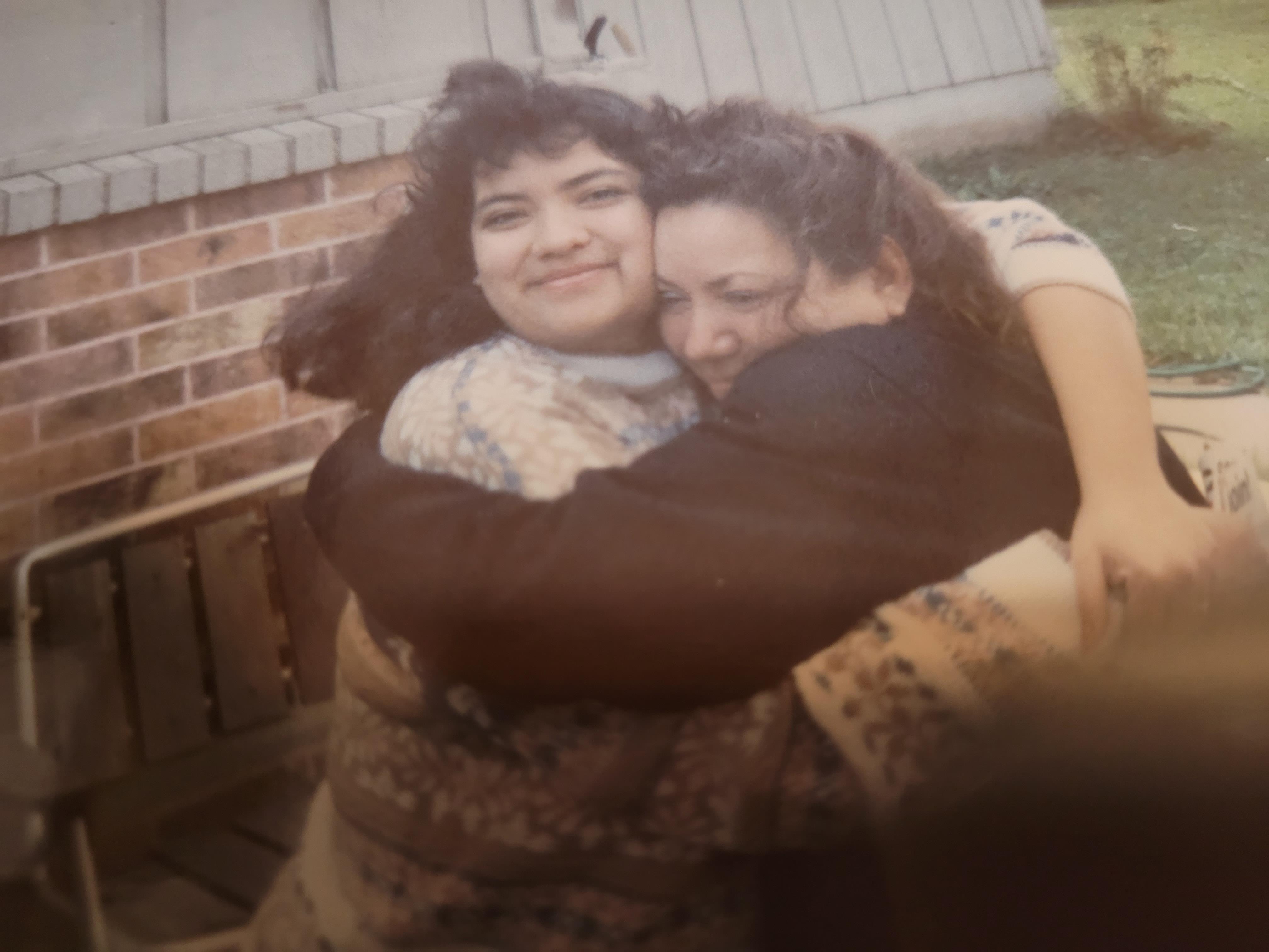 Two women hugging each other