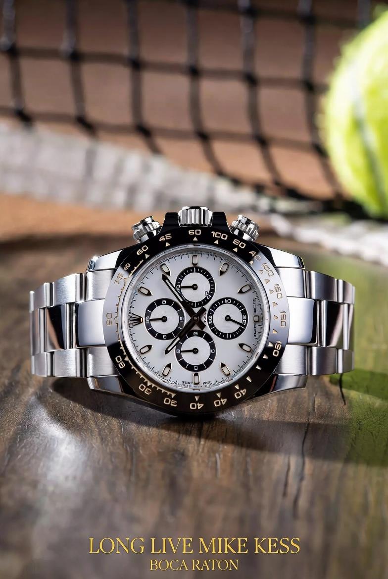 A silver watch with a tennis ball in the background