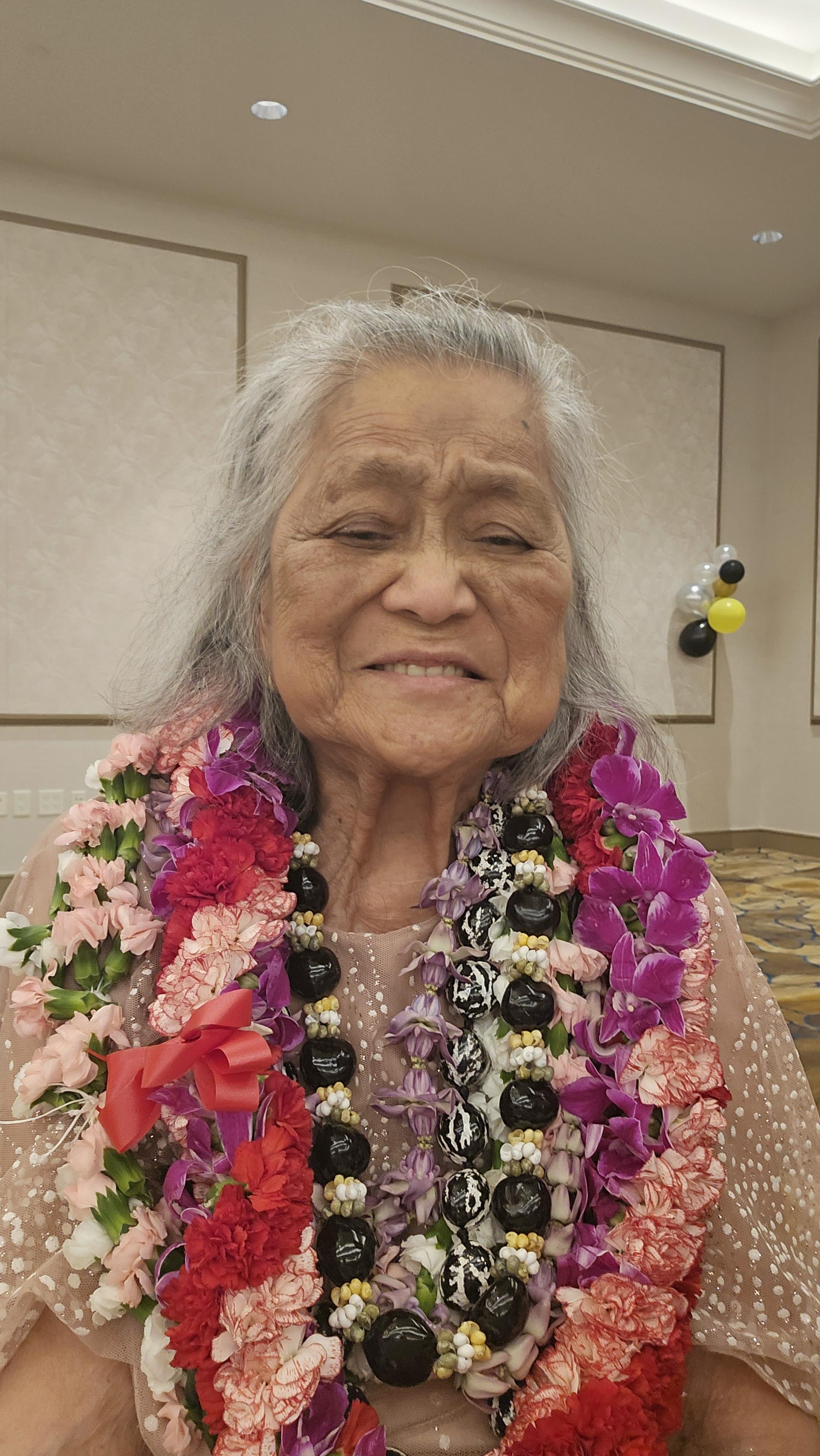 An old woman wearing a flower necklace