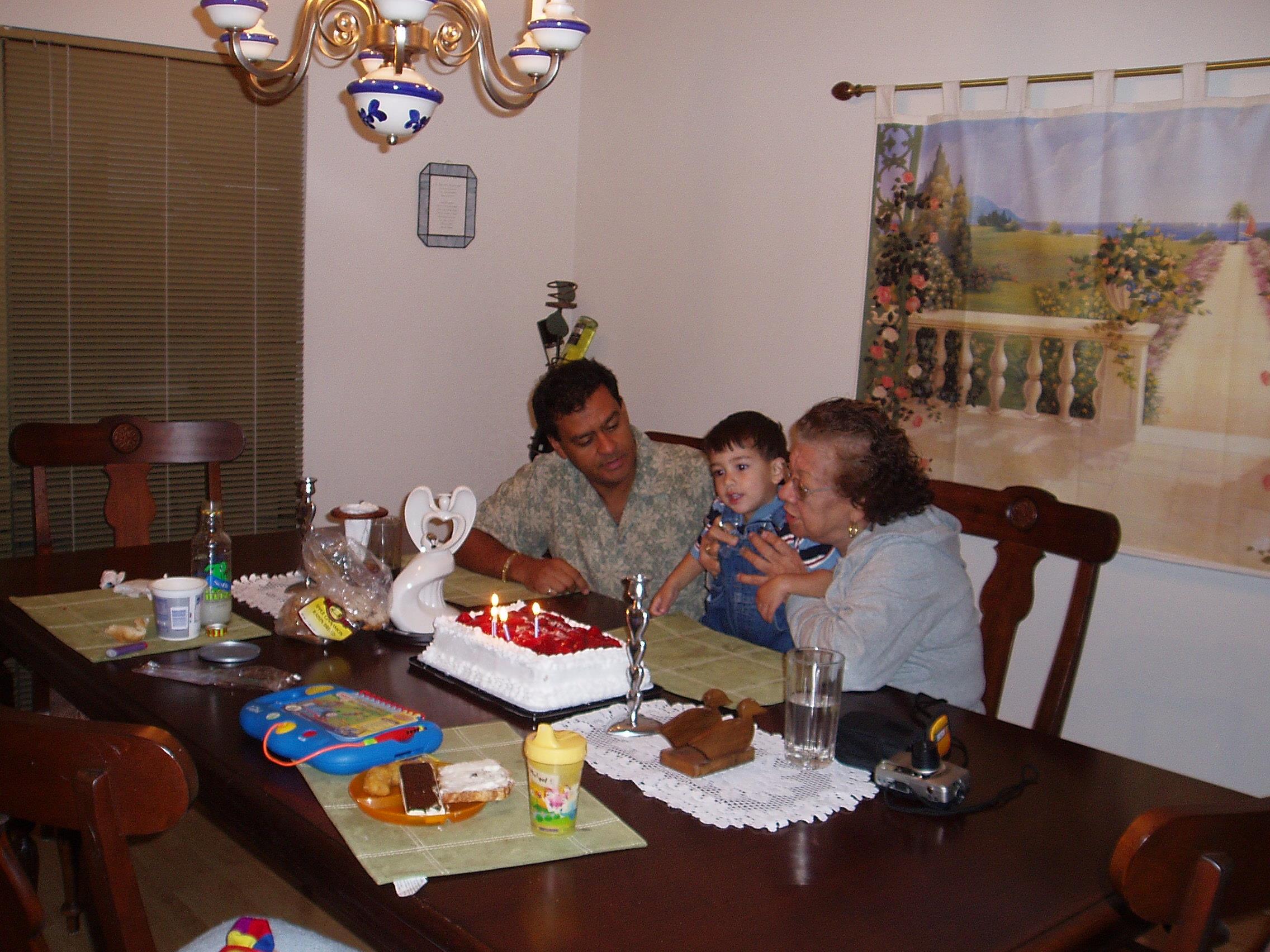 A family sitting at a table with a cake