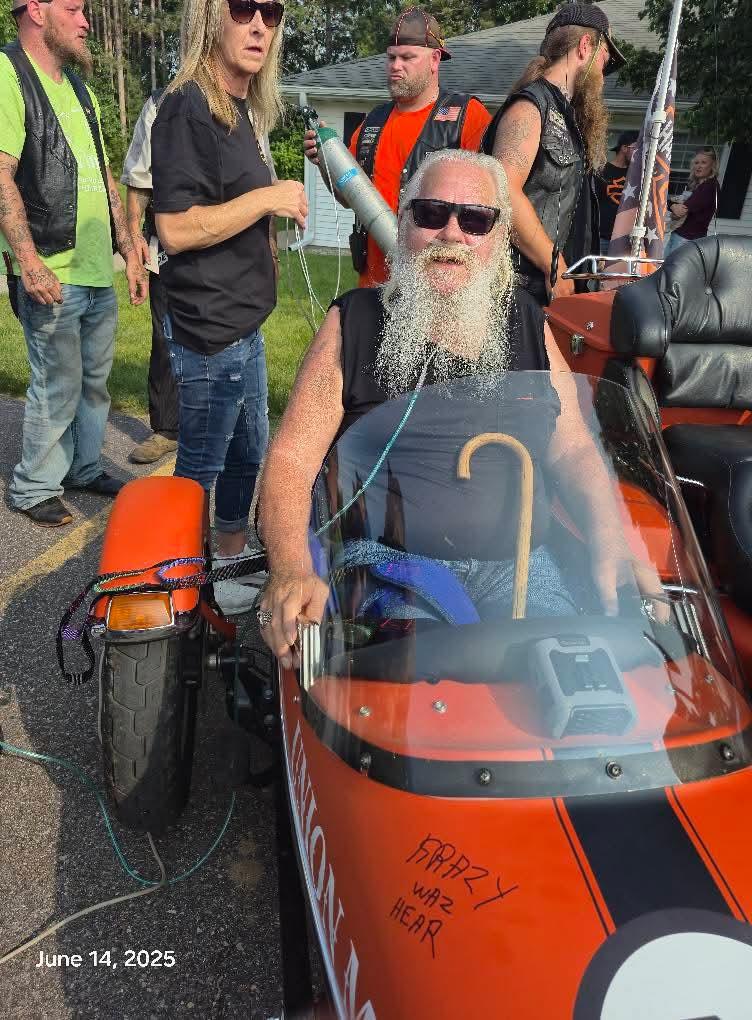 A man in a motorcycle with a beard