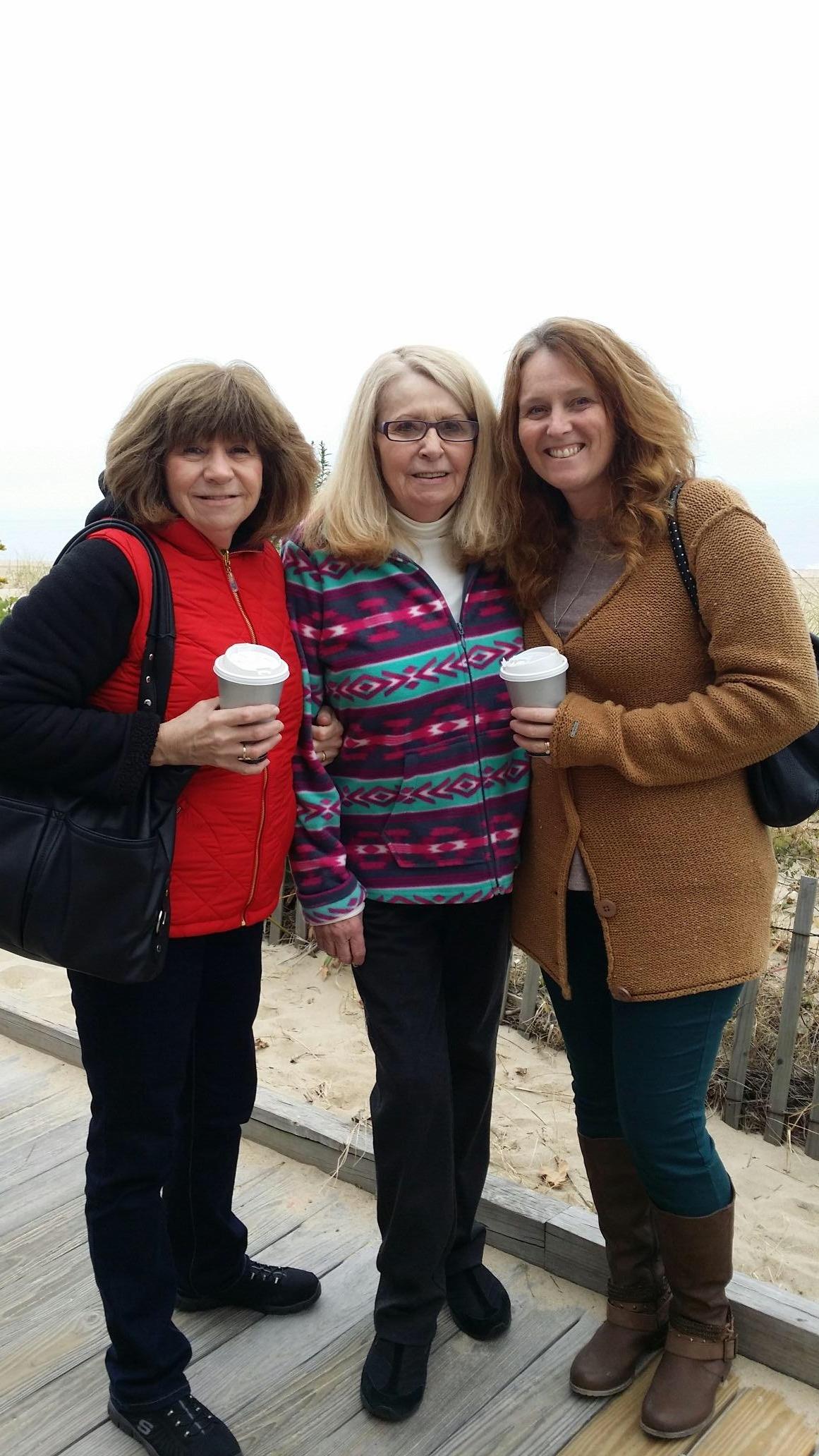 A group of women standing together holding coffee cups